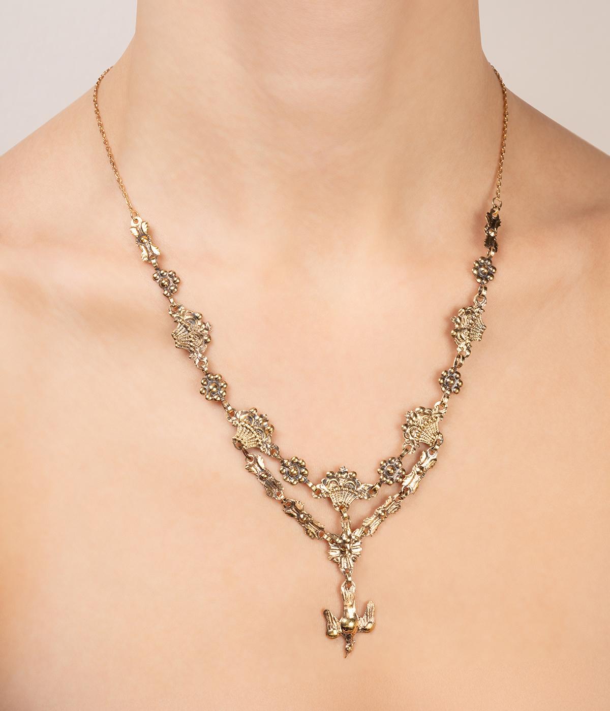 Collier antico di origine provenzale in vermeil del primo decennio del 19° secolo, ornato da corbeilles de fleurs e da un saint-esprit su un primo anello. Il secondo brano, ornato di motivi fantaisisti, è un Saint-Esprit più importante. La chaîne