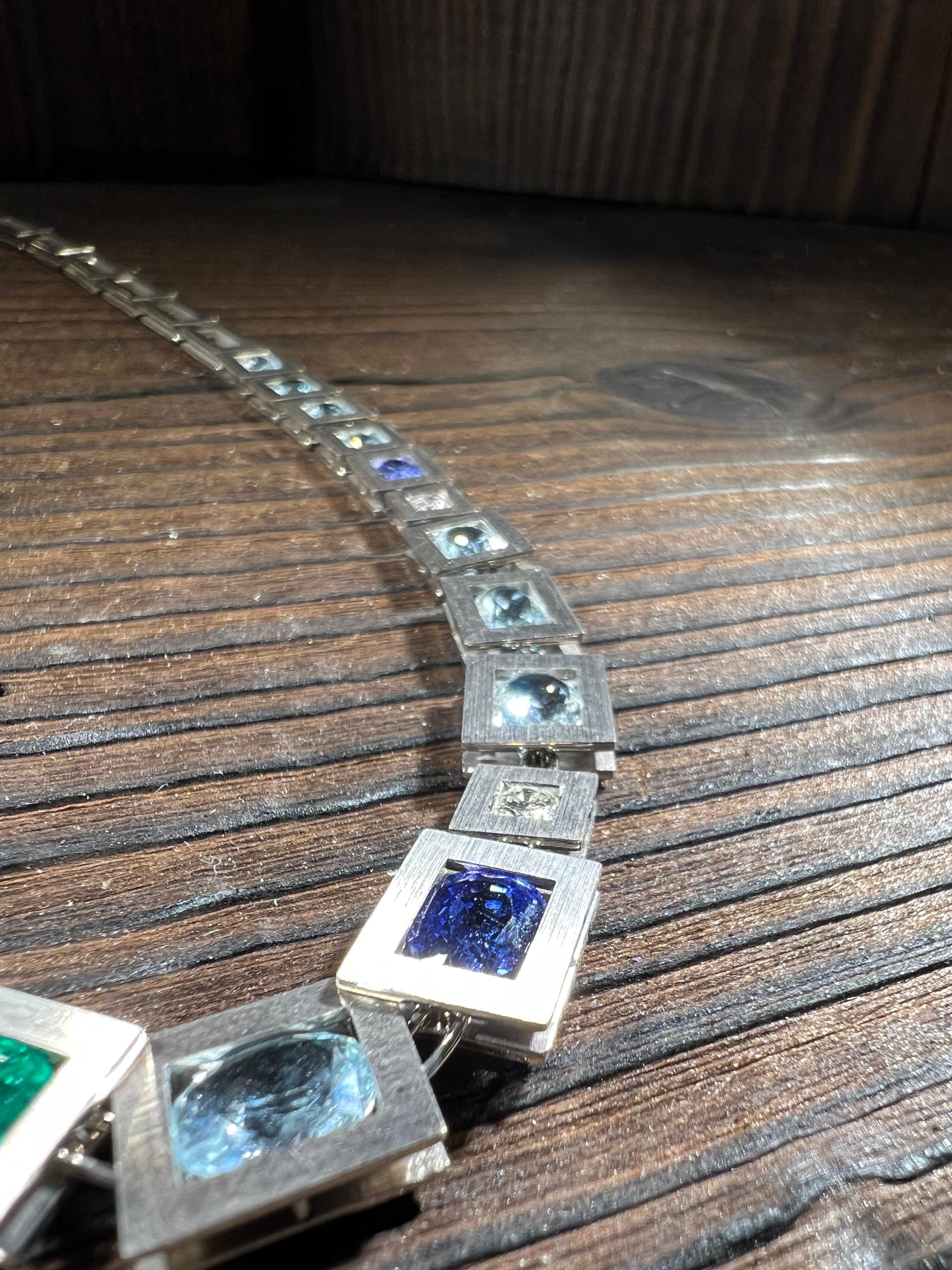 Questo esclusivo collier è stato realizzato in oro massiccio da 18 carati e contiene 5 brillanti con un peso di circa 0,95 carati, uno smarago intenso, 14 acquamarine chiare e 3 tansaniti chiare. Jedes Glied der Kette wurde individuell von Hand