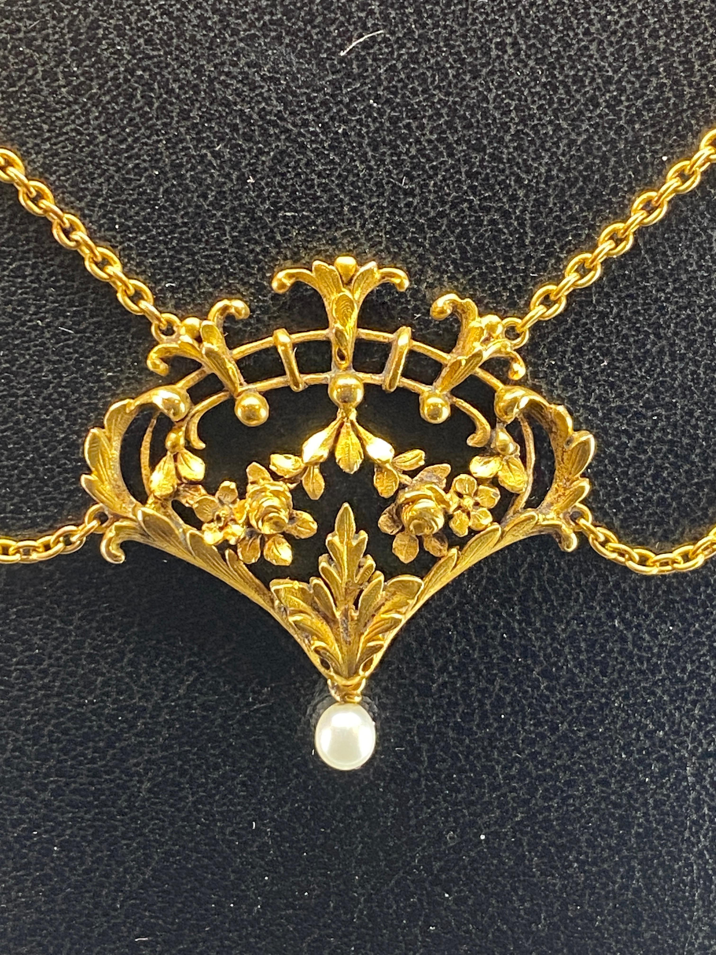 Magnifique collier en or 18 carats ( poinçon tête d’aigle ) d’ époque fin 19 ème siècle. Il est constitué de 5 motifs principaux ajourés à décor de fleurs, de feuillages, de treillage en arceaux et de perles d’or. Chaque élément retient en pampille