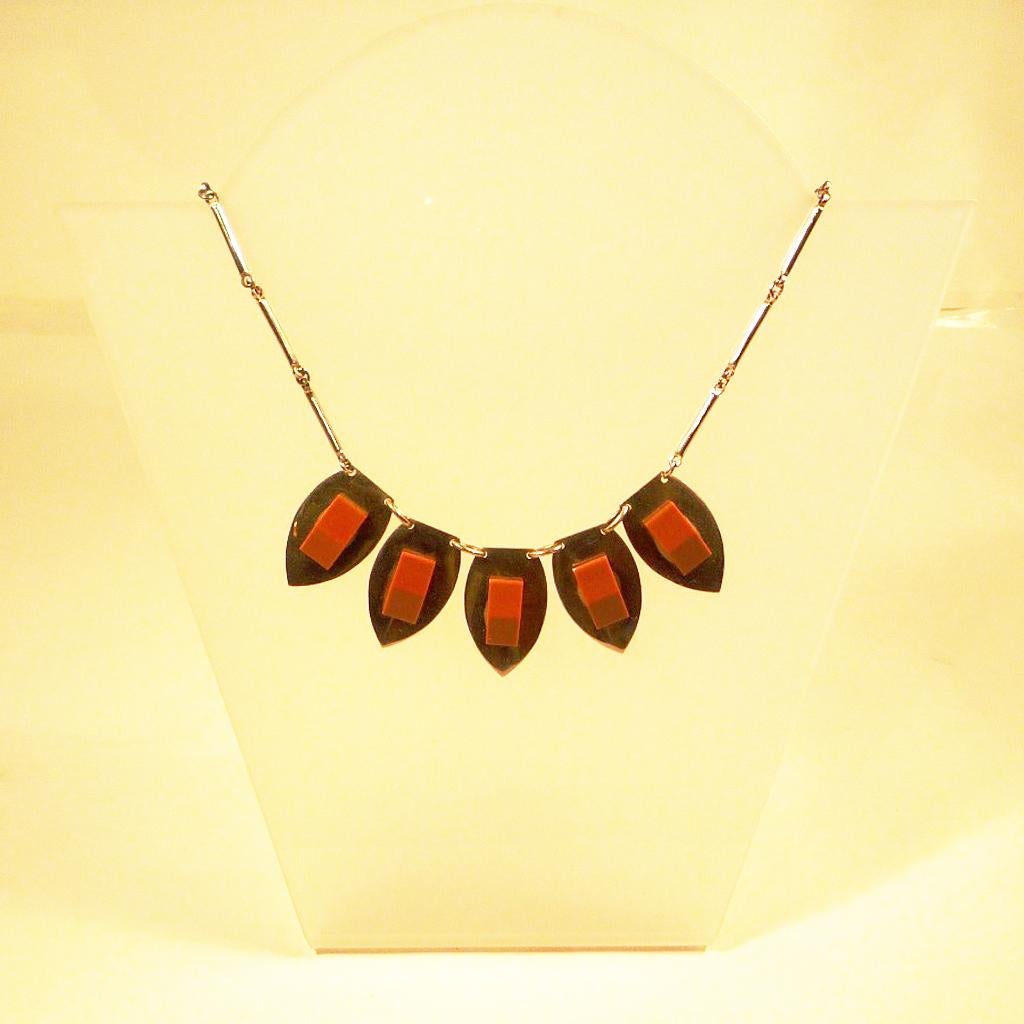 Collier in Chrome and Galalith by Jakob Bengel, around 1920/30

Necklace of the famous jewellery manufacturer Jakob Bengel from Idar-Oberstein, chrome elements with brown applications from brown galalith; size of the heart-shaped elements 25×40