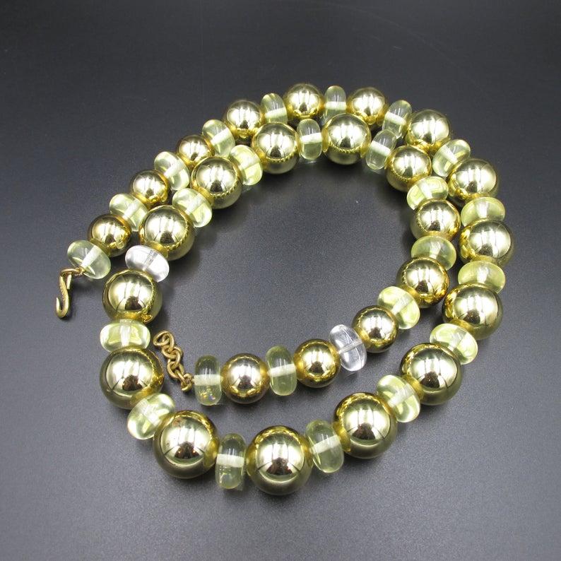 Superbe collier haute couture de la maison Yves Saint Laurent datant des années 70.
Il est réalisé en perles de résine et plastique de couleur or et transparentes .
Collier en bel état , quelques petits manques de dorures sont à noter par endroit