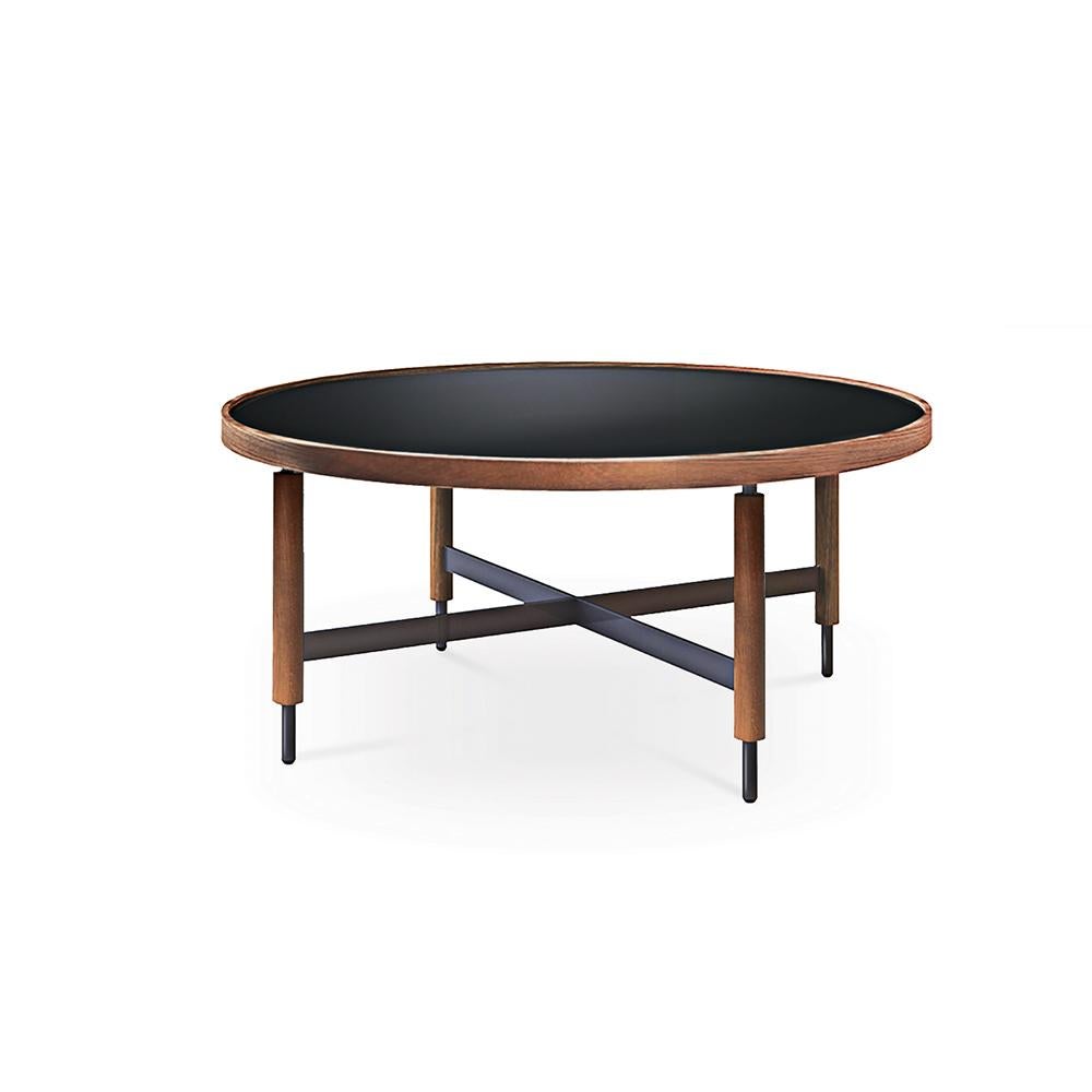Collin center table by Collector
Materials: Table top in black ultra-compact glass with an oak frame. Legs in oak with black lacquer metal details.
Dimensions: Ø 80 x H 35 cm

The slender legs of wood and metal, the beautiful crossing details