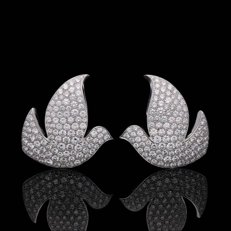 A pair of 'Colombes de la Paix' earrings by Cartier 2001, each earring designed as the stylised profile of a dove, made in 18ct white gold and pavé set throughout with round brilliant cut diamonds, with clip fittings.

Round brilliant cut diamonds