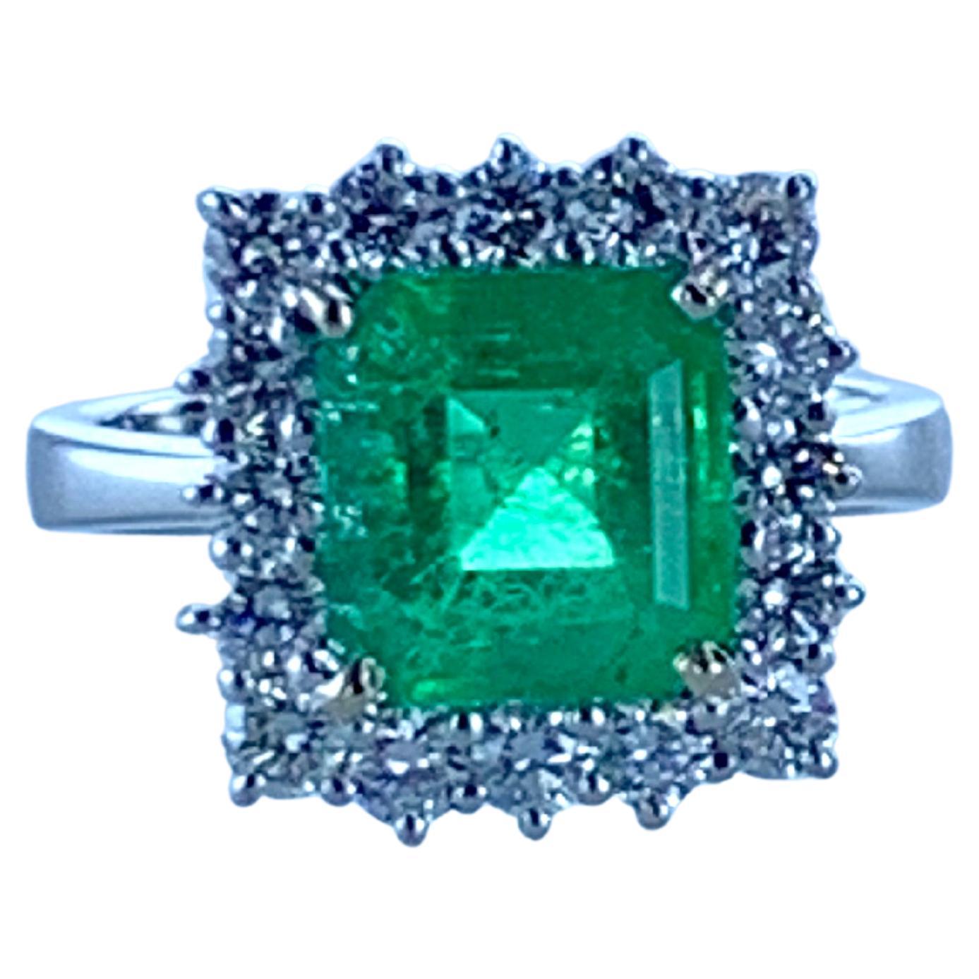 This  3.26 Carat Colombian Emerald and 1.02 Carat 18Kt White Gold Halo Diamond Ring, is both striking and a real statement on the hand. 

The square cut emerald is clear in color radiating a beautiful green, and surrounded by white diamonds in a