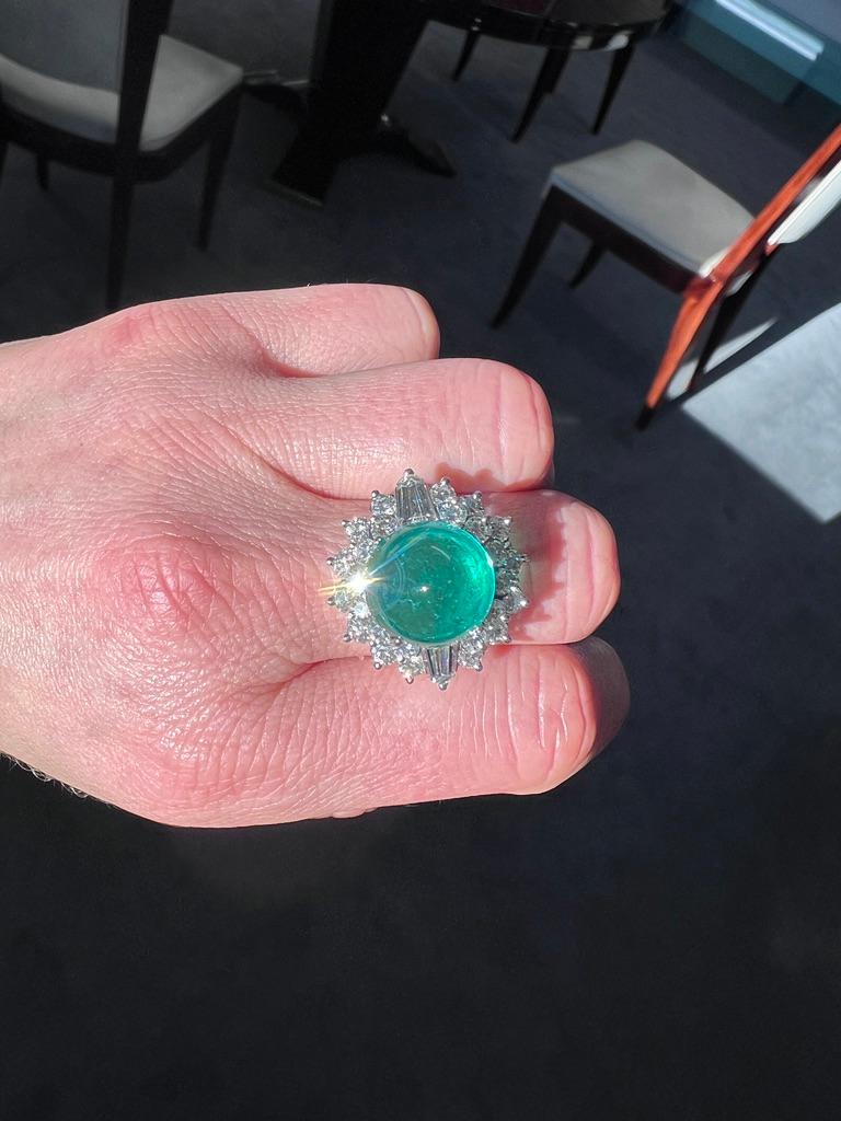This exquisite 15-carat Colombian emerald ring is a testament to timeless elegance. At its heart lies an AGL-certified emerald of Colombian origin, showcasing a double cabochon cut with vibrant green hues and minor to moderate oil treatment.