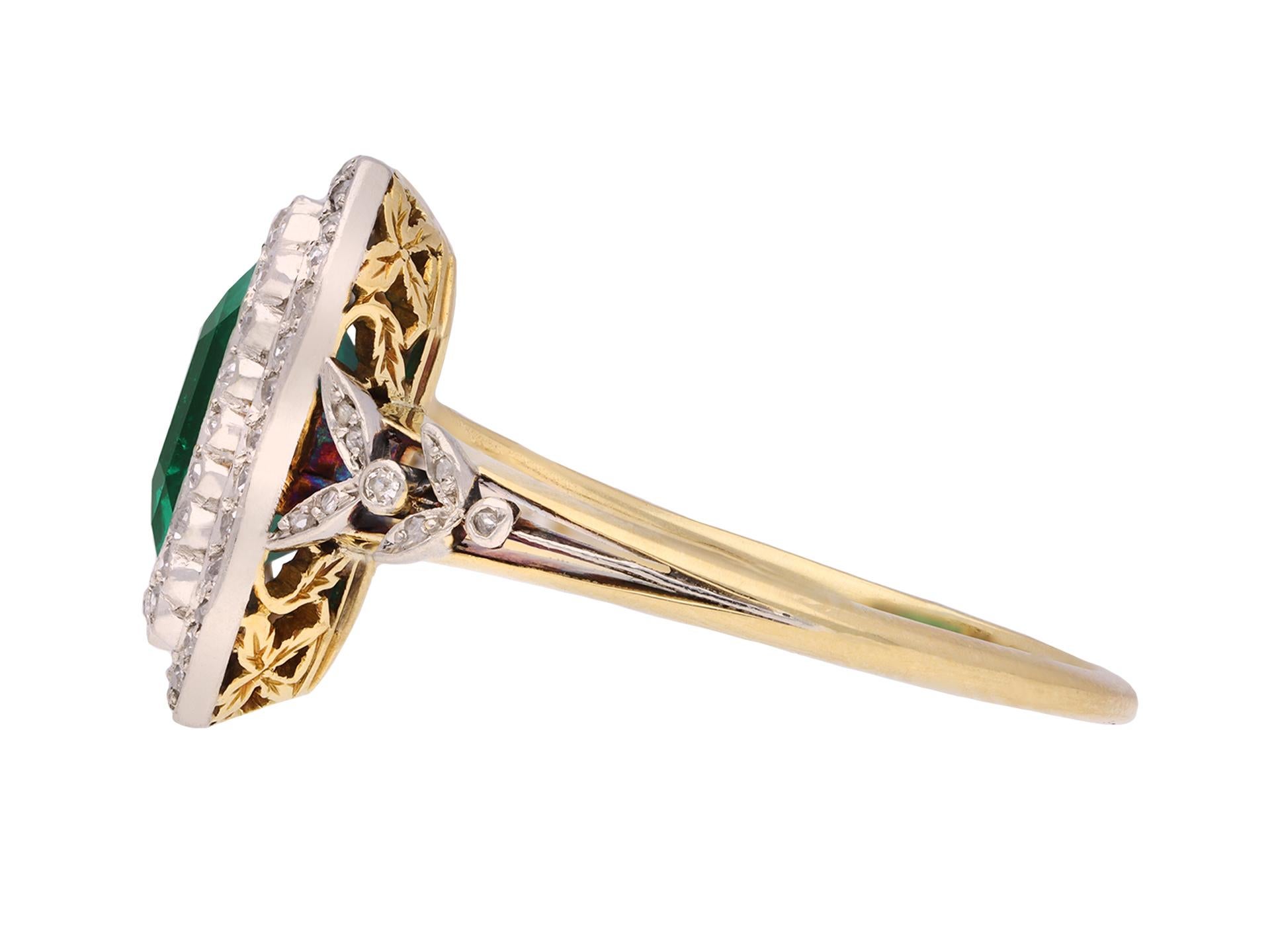 Ring mit kolumbianischem Smaragd und Diamantcluster. In der Mitte ein achteckiger natürlicher kolumbianischer Smaragd im Smaragdschliff mit geringfügiger Klarheitsverbesserung in einer offenen Rubover-Fassung mit einem ungefähren Gewicht von 1,50