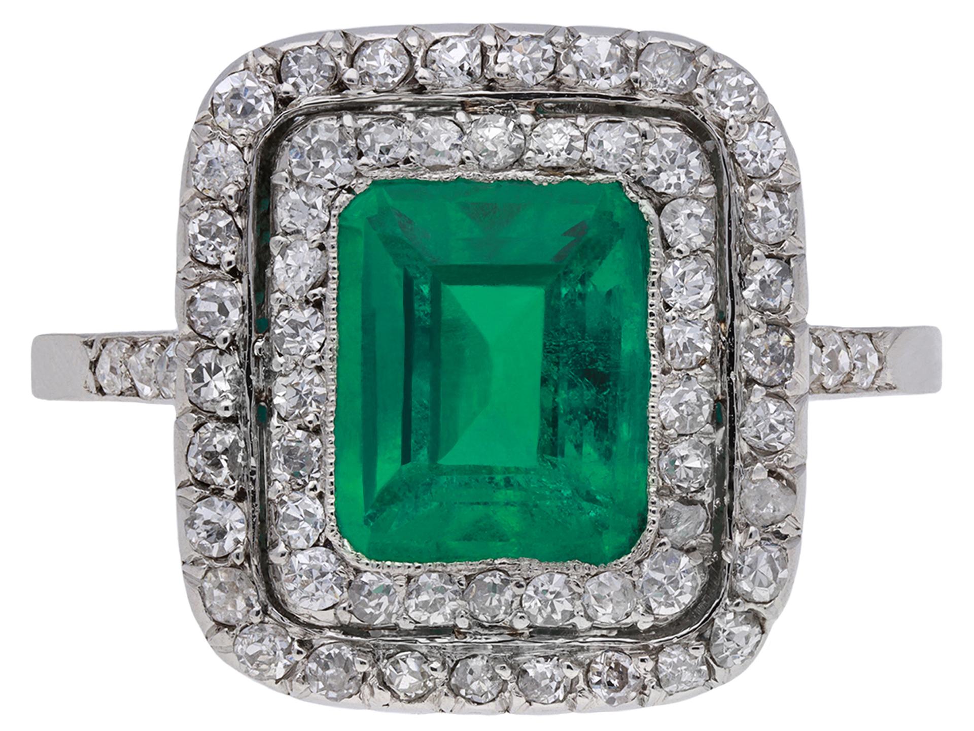 Ring mit kolumbianischem Smaragd und Diamantcluster. In der Mitte befindet sich ein achteckiger natürlicher kolumbianischer Smaragd im Stufenschliff mit geringfügiger Verbesserung der Klarheit in einer offenen Fassung mit einem ungefähren Gewicht