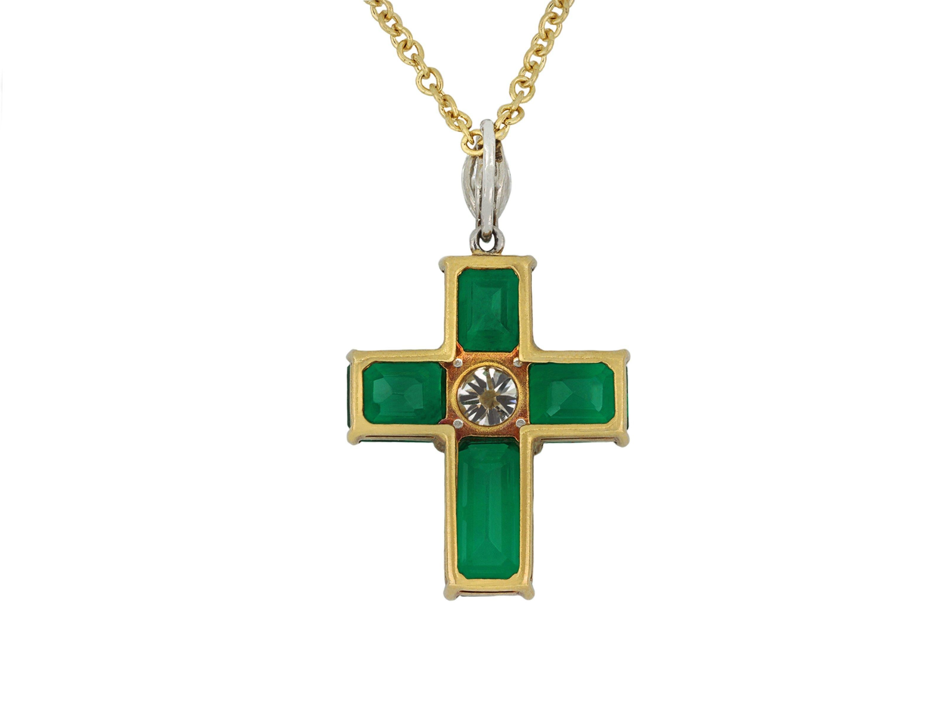 Colombian emerald and diamond cross pendant. Set to centre with a round transitional cut diamond in an open back claw setting with an approximate weight of 0.40 carats, flanked by four rectangular step-cut natural Colombian emeralds with minor