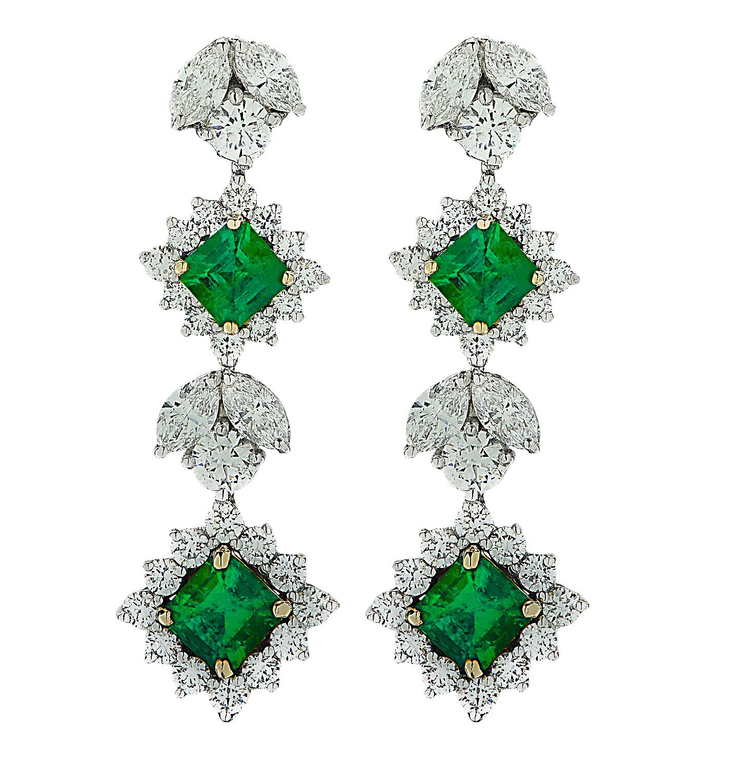 Spectacular Emerald and Diamond dangle earrings crafted in Platinum and 18 karat yellow gold, showcasing 4 square emerald cut green emeralds weighing approximately 2.64 carats total, and 60 mixed round brilliant cut and marquise cut diamonds