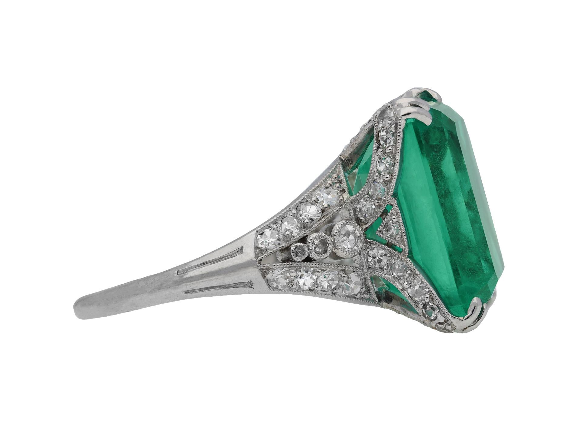 Colombian emerald and diamond ring. Set to centre with an octagonal emerald-cut natural Colombian emerald with no colour enhancement and minor clarity enhancement in an open back claw setting with a weight of 9.70 carats, further decorated with