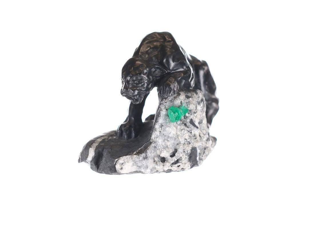 This beautiful and one-of-a-kind rough Colombian emerald sculpture. It displays an exotic, and rare black panther made of black and gray shale with a hint of pyrite that is stalking its prey. The rough Colombian emerald can be found on the mountain,