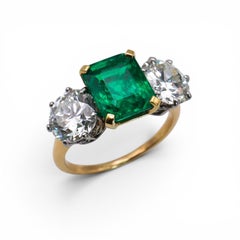 Anello a tre pietre con smeraldo colombiano, diamanti, oro 18 carati e platino