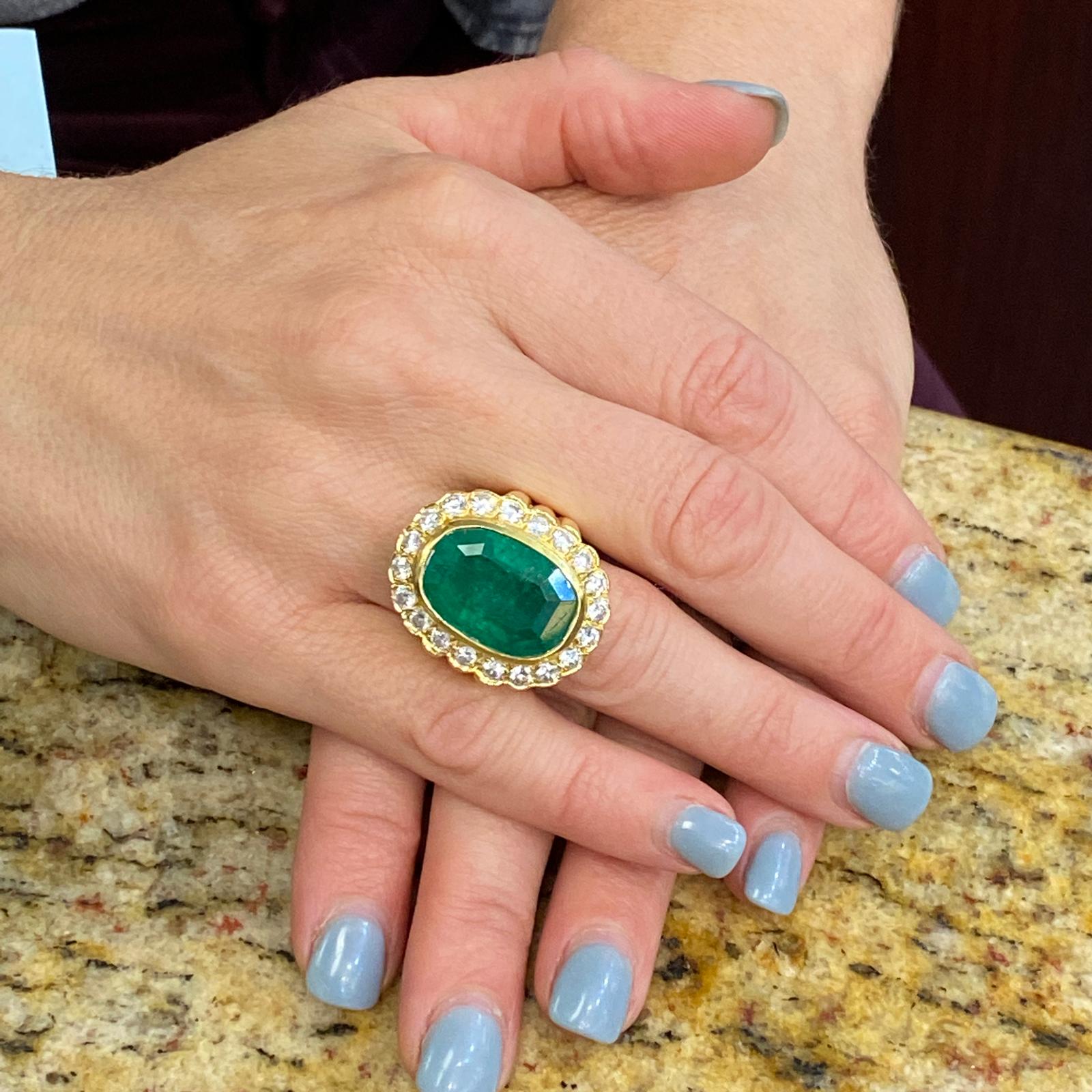 Stunning Colombian Emerald Diamond Cocktail Ring hand crafted in 18 karat yellow gold. The 11.00 carat oval cut Colombian emerald has a deep green color and is certified by the AGL. The emerald is surrounded by 20 round brilliant cut diamonds