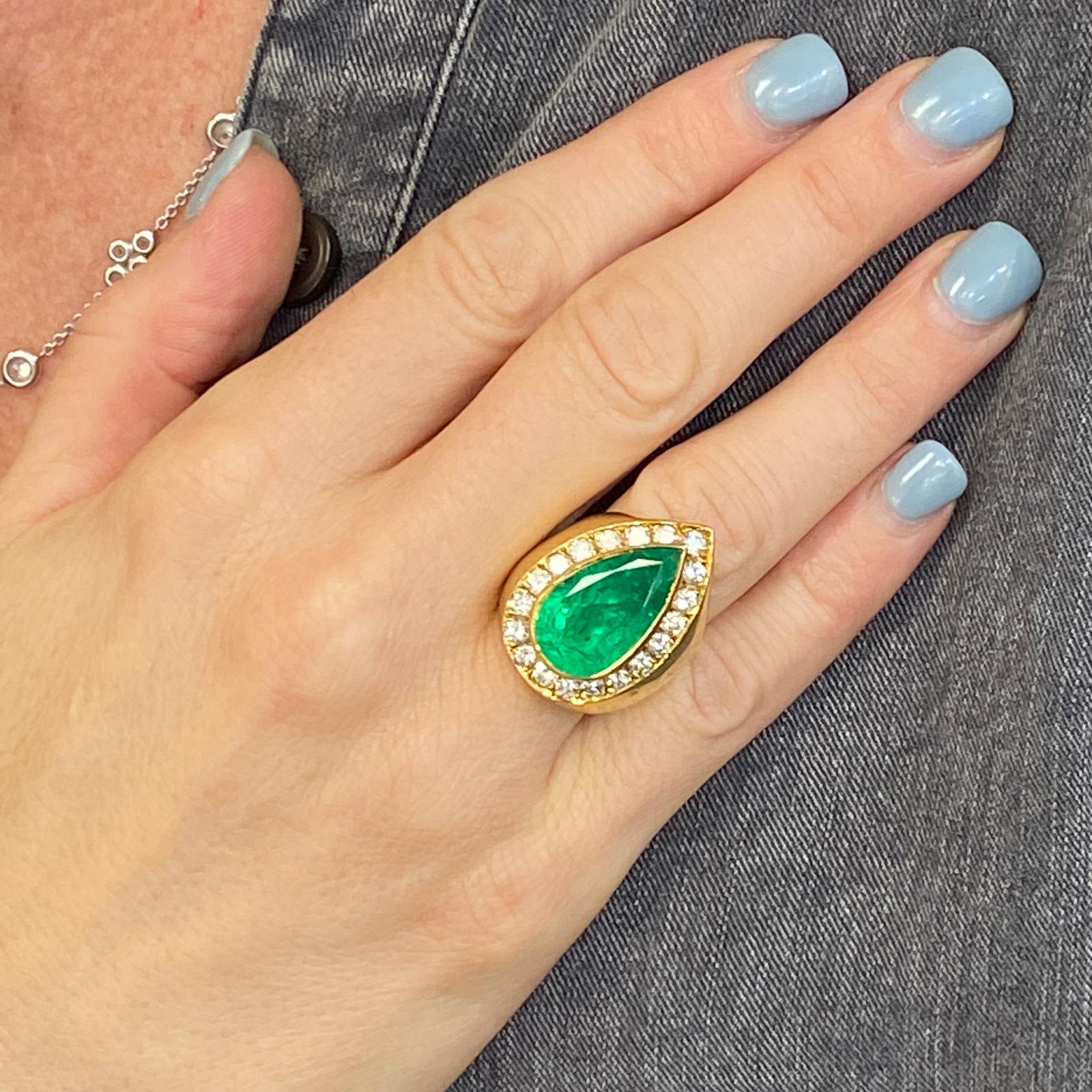 Fabulous Colombian emerald diamond cocktail ring hand crafted in 18 karat yellow gold. The 8.50 carat Colombian Emerald is certified by the AGL. The emerald is surrounded by 19 round brilliant cut diamonds weighing 1.70 carat total weight and graded