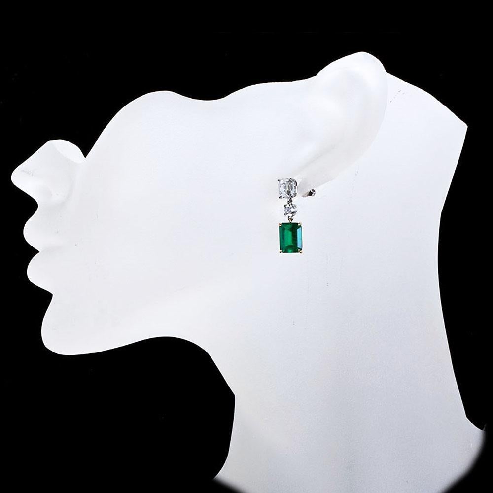 A fine pair of Colombian Emerald and Asscher cut diamond in platinum and 18k gold drop earrings.  Contains two rectangular step cut Colombian emeralds weighing 5.46 ctw suspended from two Asscher cut diamonds 3.62 ctw, F color, VS1 clarity with