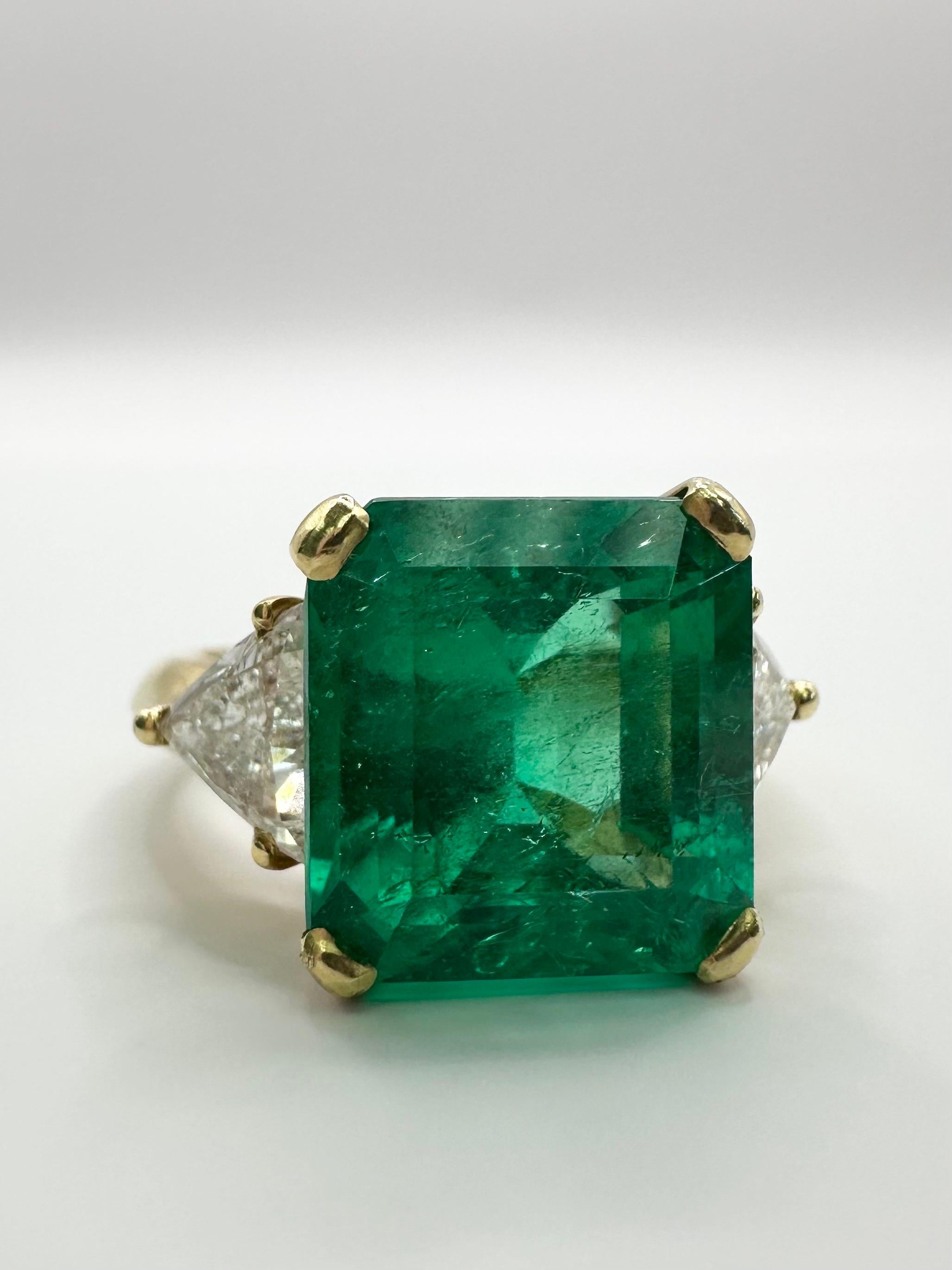 Fine Emerald Diamond ring in 18KT yellow gold, made with a large 6.98 carats emerald and flanked by a trillion brilliant on either side! Certificate of authenticity comes with the purchase for the gemstone and the ring.

Metal Type: 18KT

Natural