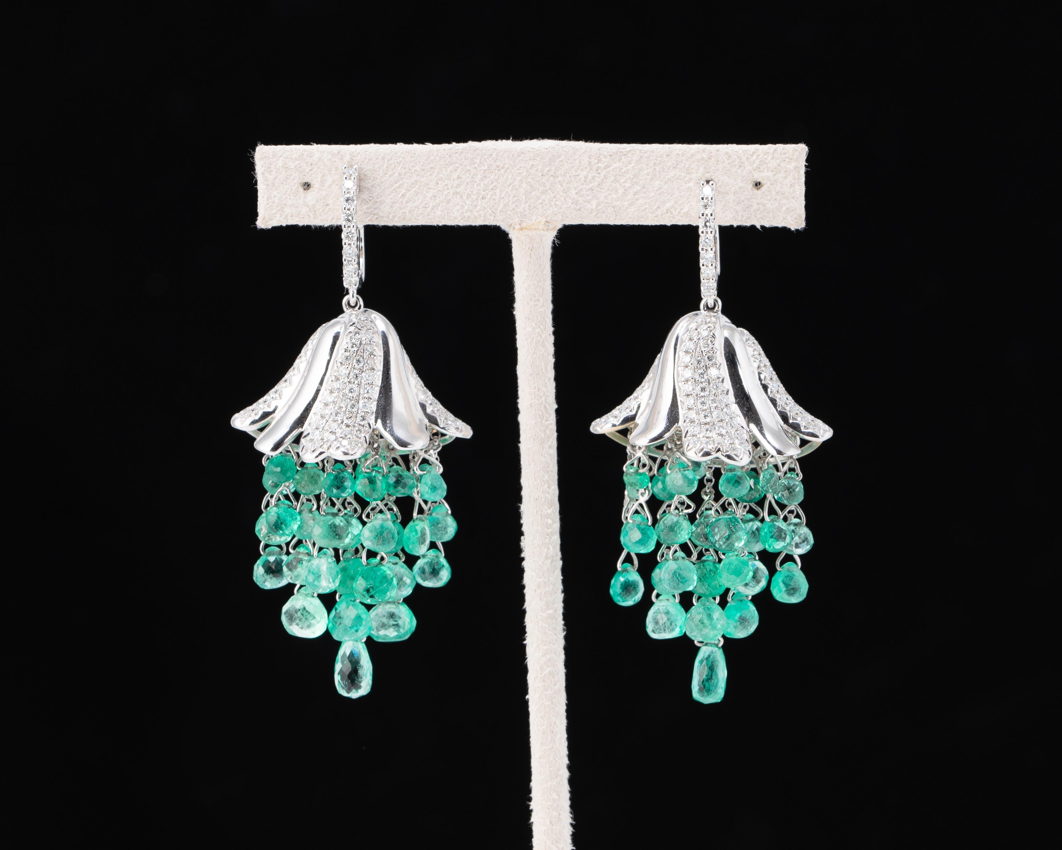 A very unique pair of 20.19 carat Colombian Emerald earrings, delicately dangling in Gold wire, from a White Diamond and 18K Gold cap. 1.47 carats of White Diamonds are used, and all stones are set in 17.43 grams of 18K White Gold. 
Free shipping