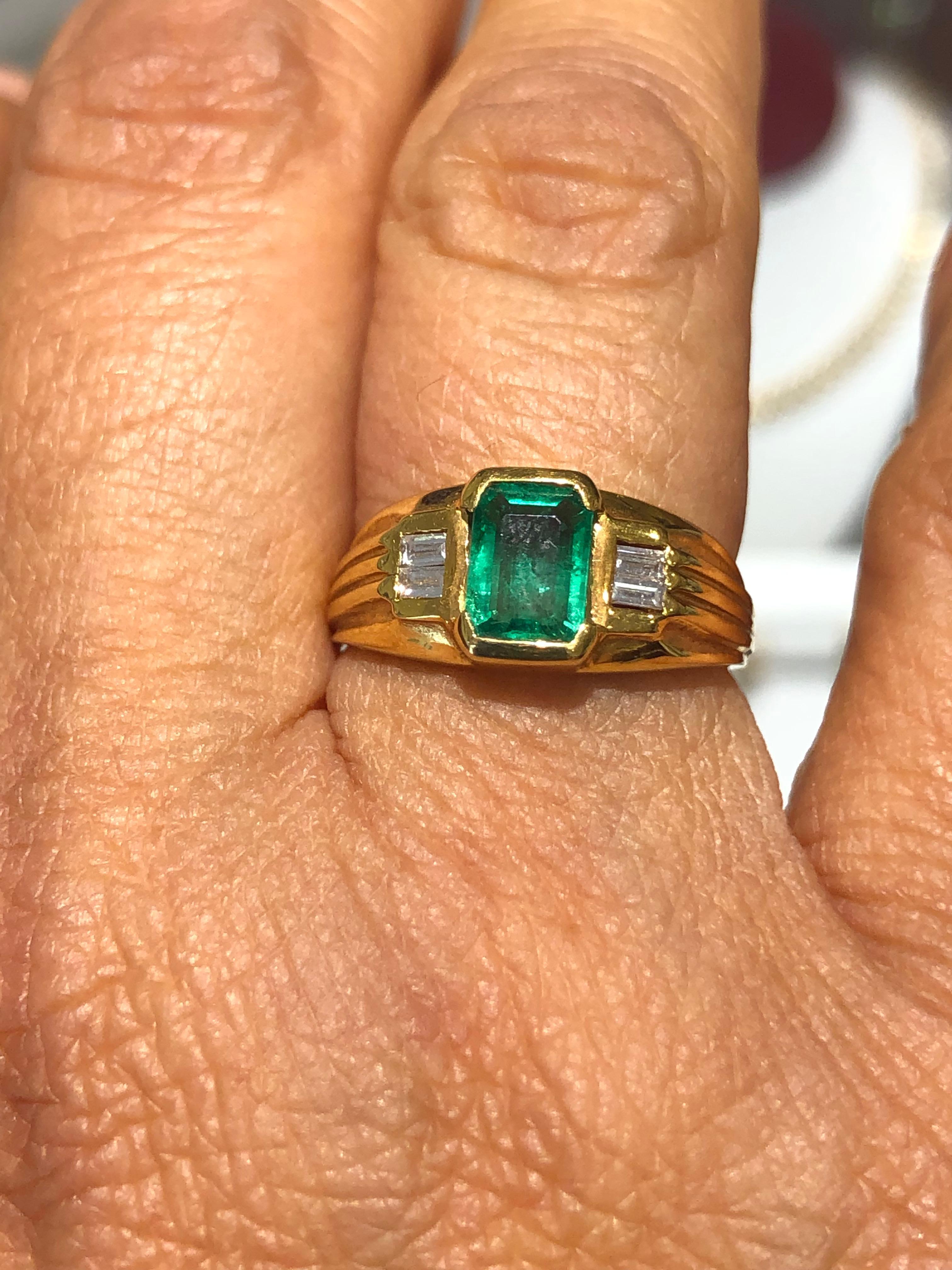 This estate ring displayed is a bluish-green Colombian emerald, solitaire, emerald-cut bezel ring in 18K yellow gold. This gorgeous solitaire ring carries a full 0.80 carat emerald in a bezel setting. The emerald has very good clarity and luster.