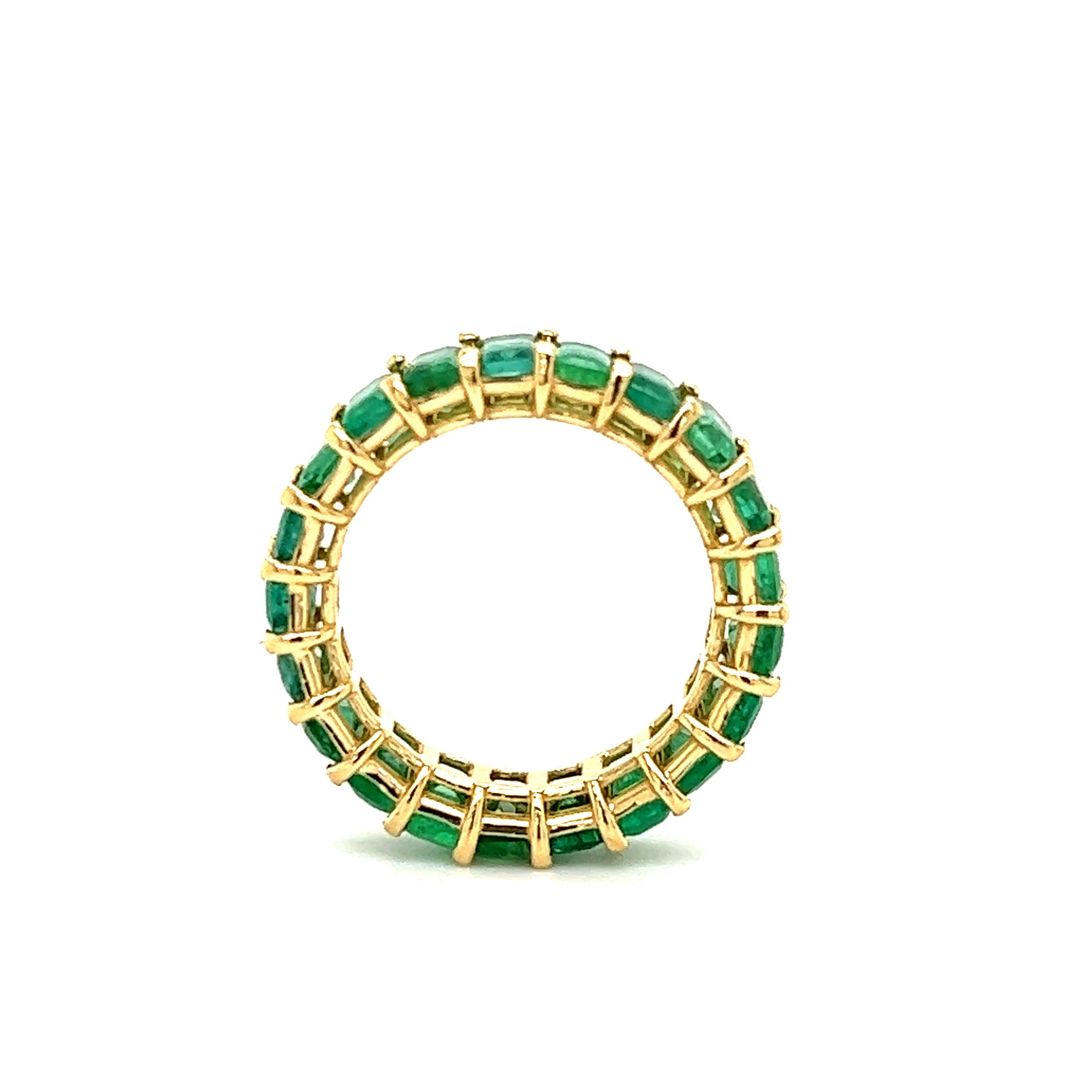 Amazing hand crafted 18k yellow gold Colombian Emerald eternity band. This ring is truly breathtaking. Each stone was matched to perfection to create this one of a kind ring. Twenty one Emeralds are set into this band, all showing a vibrant green
