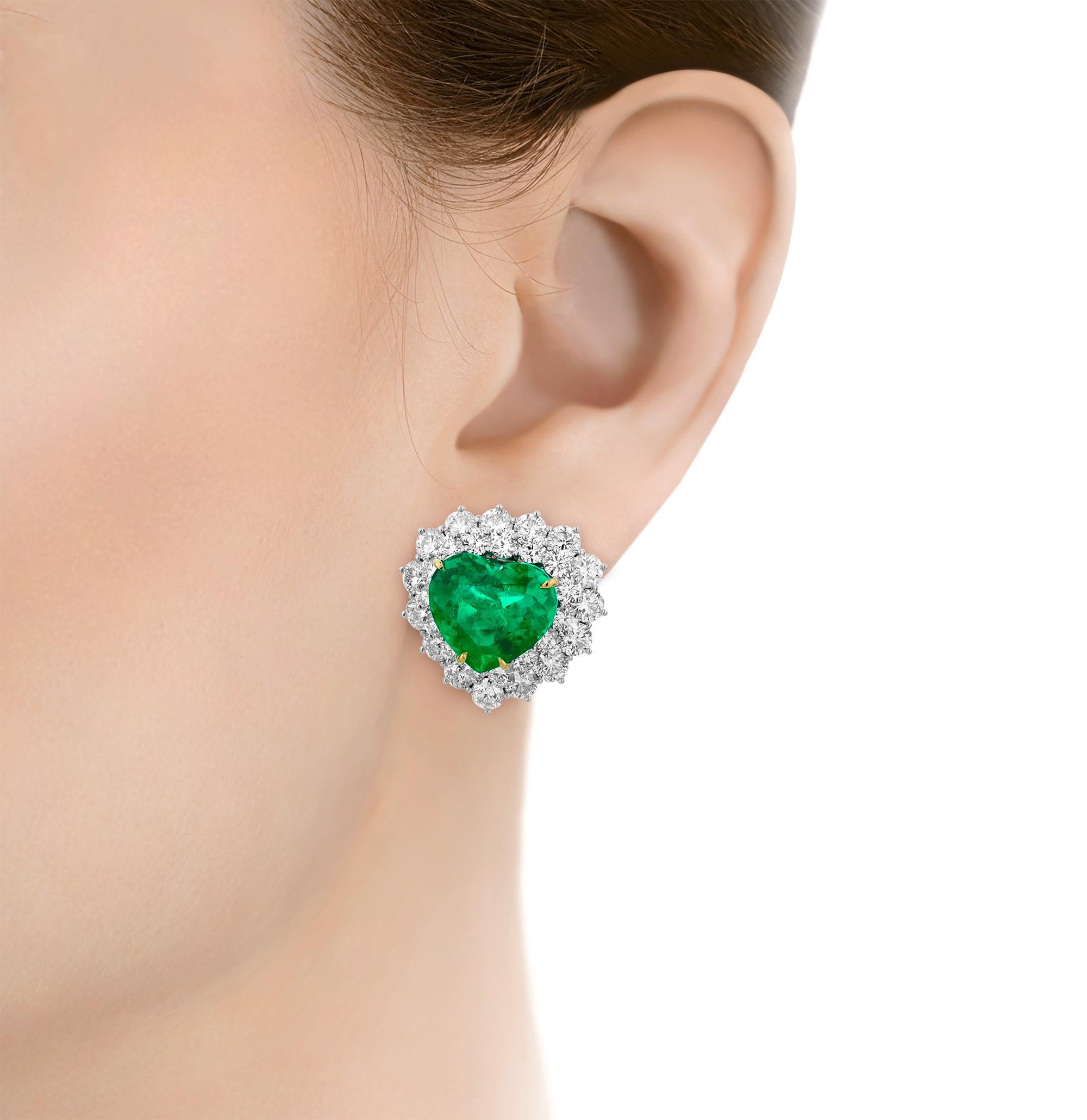 Highly rare, this stunning pair of earrings features two incredible heart-shaped Colombian emeralds. The verdant, emerald cut gems have an impressive total weight of 17.84 carats and are accompanied by a coveted certification from C. Dunaigre,