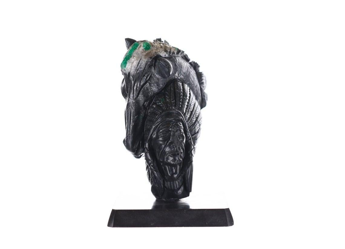 This is a beautiful and one-of-a-kind rough Colombian emerald sculpture. Displayed is a Colombian redskin Indian, with a horse morphing among its head. This piece is hand-carved, with staggering detail from top to bottom making it such a rare and