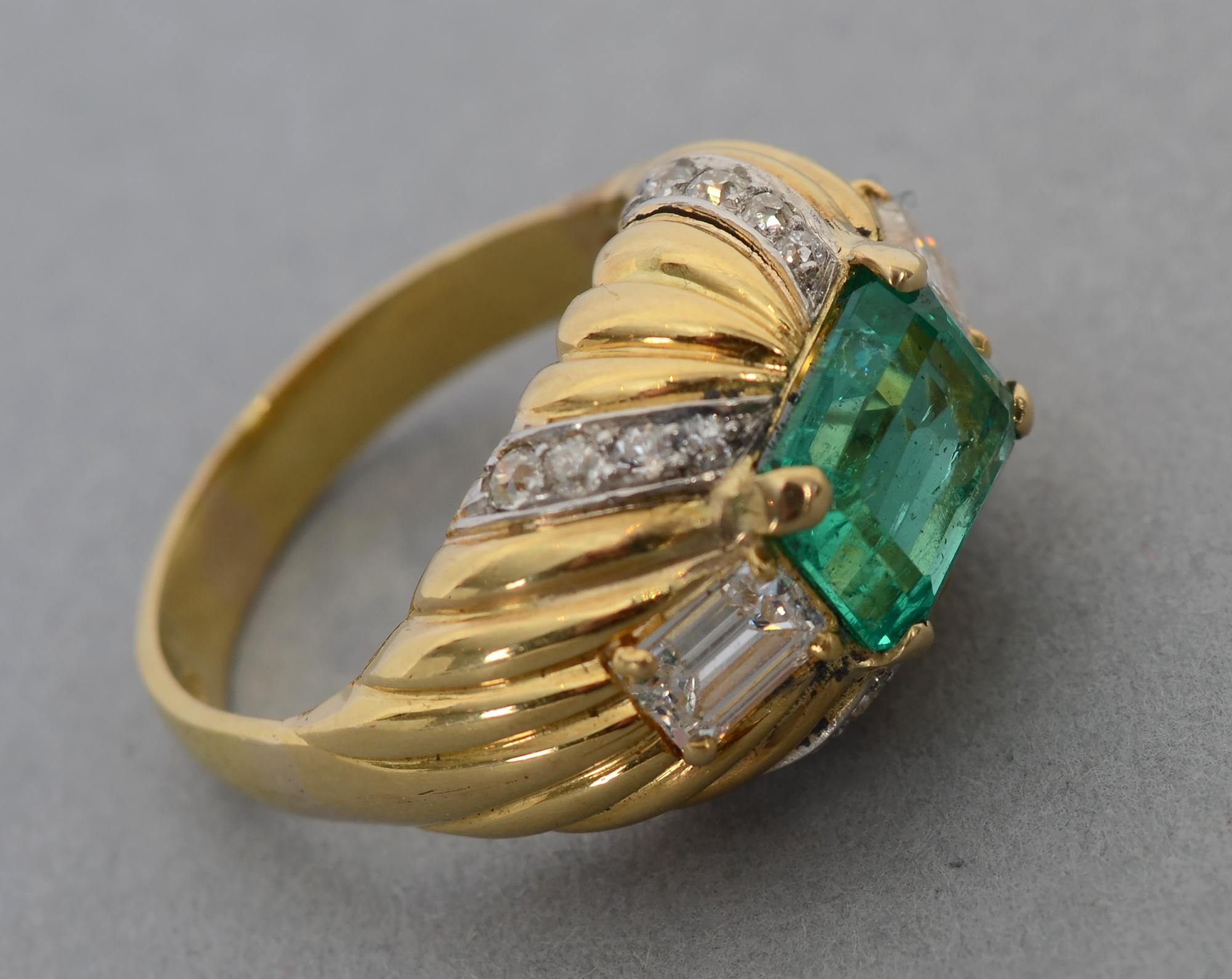 Stunning emerald and diamond ring set in 18 karat gold. The central stone is an octagonal 2.56 carat Colombian emerald; no heat as GIA tested.  The stone measures 9.68 x 7.62 x 4.66 mm. On either side is an octagonal diamond weighing approximately