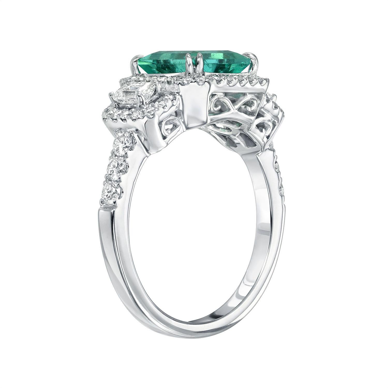 Very lively medium green 1.75 carat Colombia Emerald ring in 18K white gold, flanked by a pair of emerald cut diamonds and surrounded by round brilliant diamonds weighing a total of 0.83 carats.
Size 6.5. Re-sizing is complimentary upon