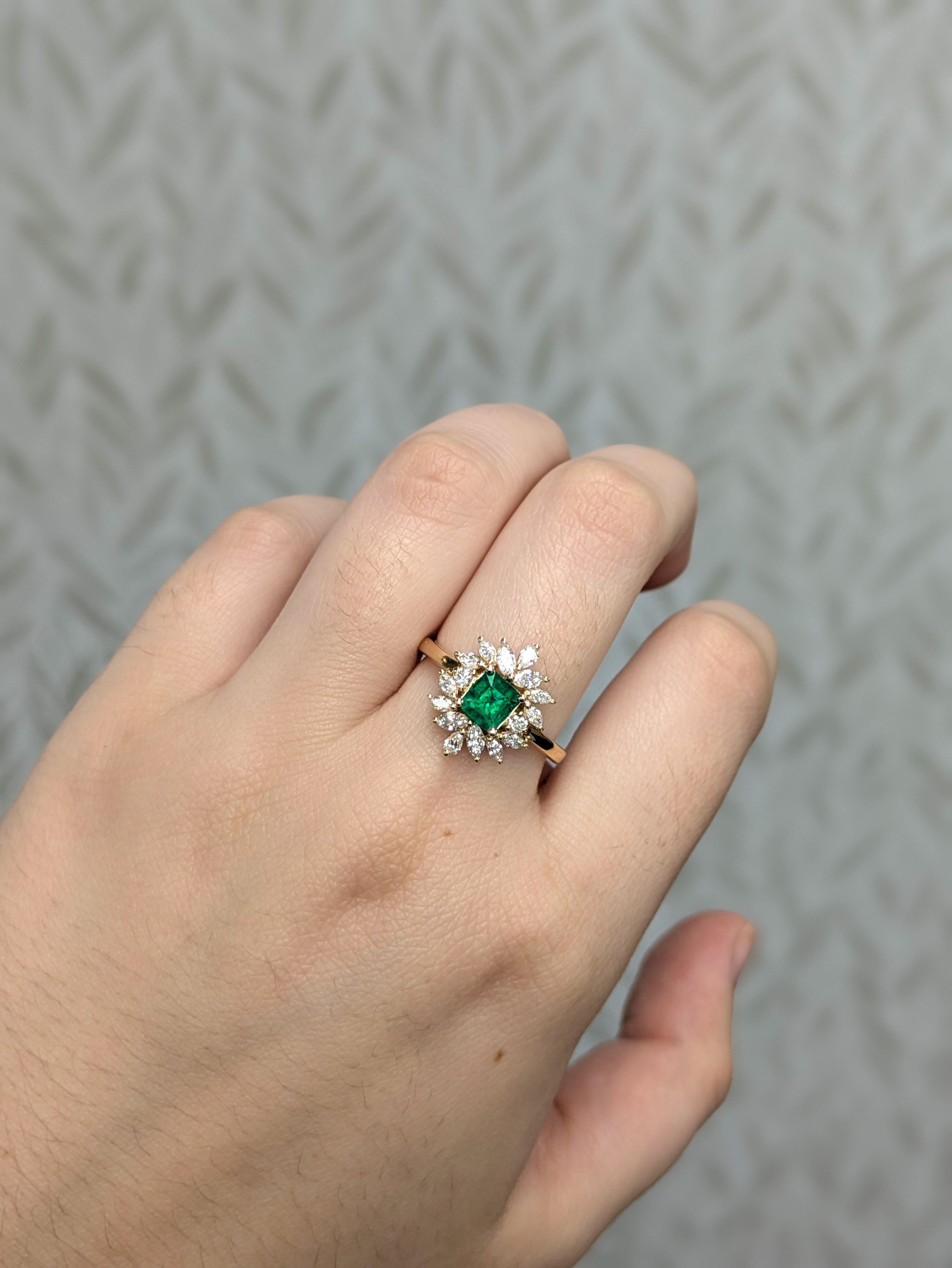 Este elegante anillo exhibe una esmeralda colombiana de 0,59 ct, tallada por expertos en una forma clásica de esmeralda de 5 mm y engastada en oro de 14k (3,22 g). El diseño presenta delicados detalles de inspiración floral, bellamente