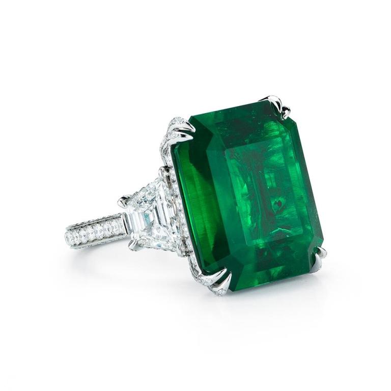 COLOMBIAN EMERALD RING WITH DIAMOND A simply stunning and substantial (AGL and Gubelin Certified) Emerald is the star of this classic platinum ring. The 17.81 ct vibrant green Emerald is embraced on both sides by high quality trapezoid cut diamonds