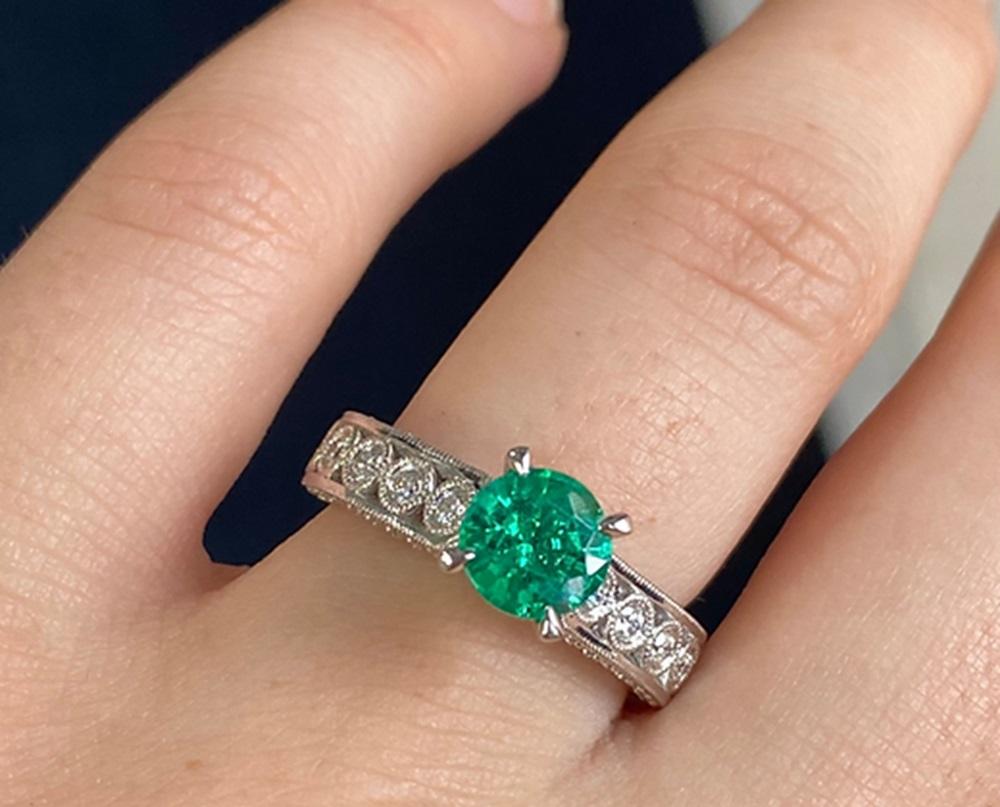 Emerald Weight: 1.00 CT, Measurements: 6.5 mm, Diamond Weight: 0.51 CT, Metal: 18K White Gold, Ring Size: 6.5, Shape: Round, Color: Intense Green, Hardness: 7.5-8, Birthstone: May