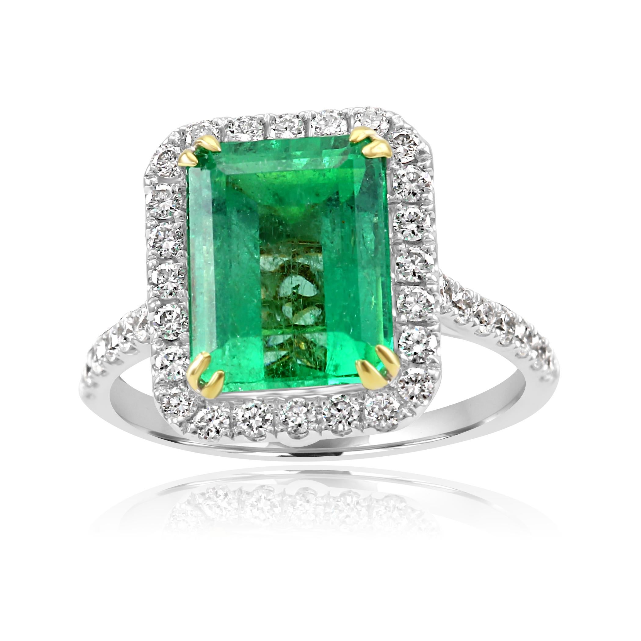 Colombian Emerald Emerald Cut 4.13 Carat encircled in a single Halo of 44 White Colorless VS-SI Diamond Rounds 0.68 Carat Set in a very Beautiful and intricately made 18K White and Yellow Gold Bridal Fashion Cocktail Ring.

Style available in