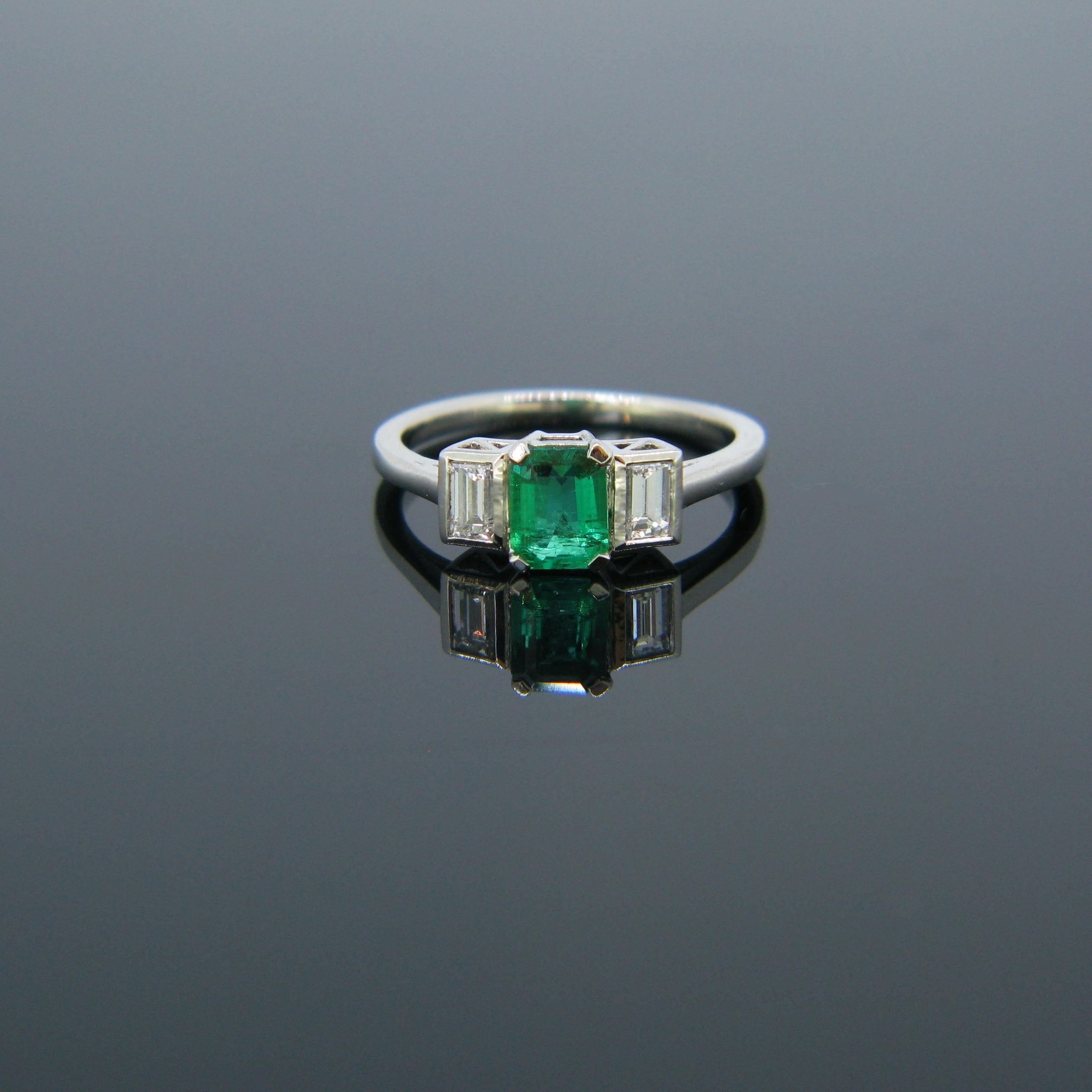 This beautiful ring is set with a Colombian Emerald Minor weighing 0.54ct and with two tappers diamonds of about 0.30ct each on both sides. It is fully made in platinum. It could be the perfect engagement ring as emerald is said to be the stone of
