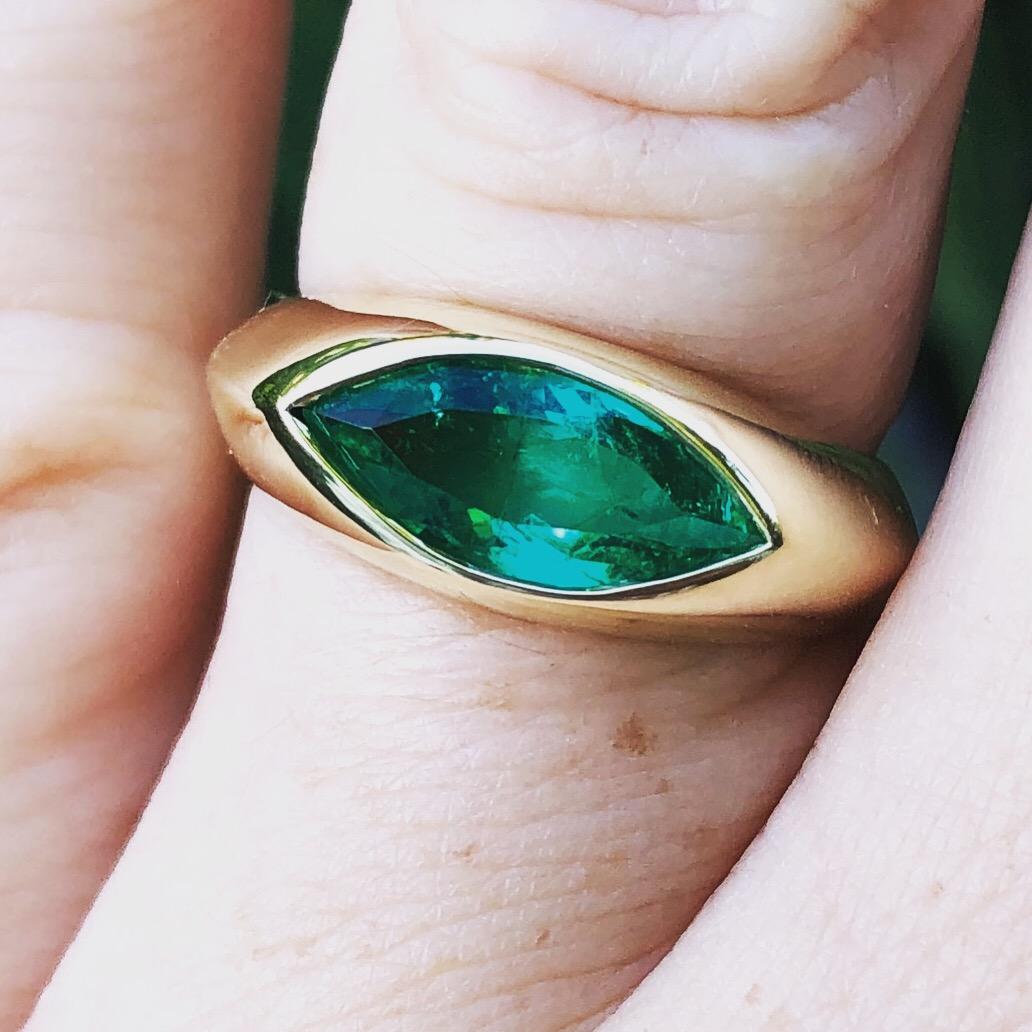 1.55 carat marquise cut Colombian Muzo Emerald is set in a hand carved wax/cast 18 karat gold gypsy set ring. The emerald had a 3 carat look with a wide spread of 14 mm x 6.44 mm. This emerald was sourced directly from Colombia through our