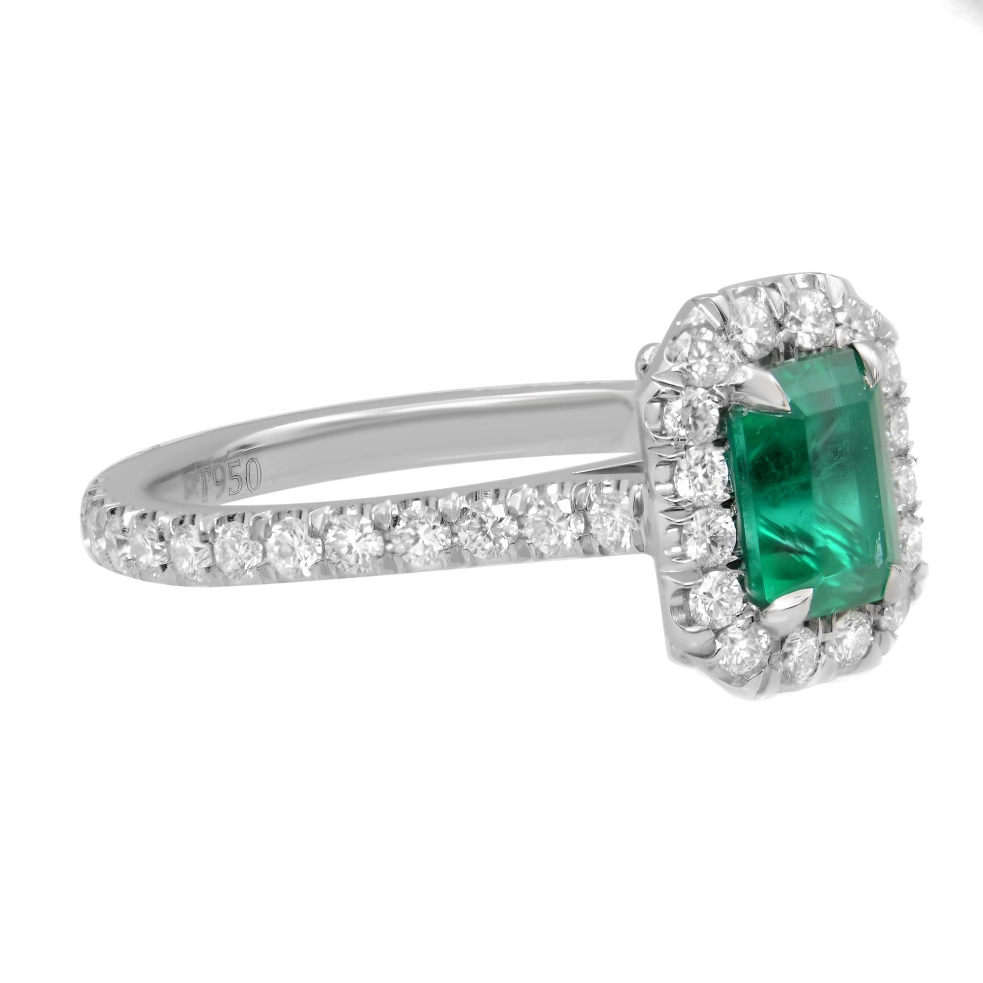 Mounted in a claw setting, 0.90 carat emerald-cut vivid green Colombian emerald that catches attention with its glorious green hue. Center stone is certified.  Diamond accents surround the gem in a sparkling halo and embellish the shank. Diamond