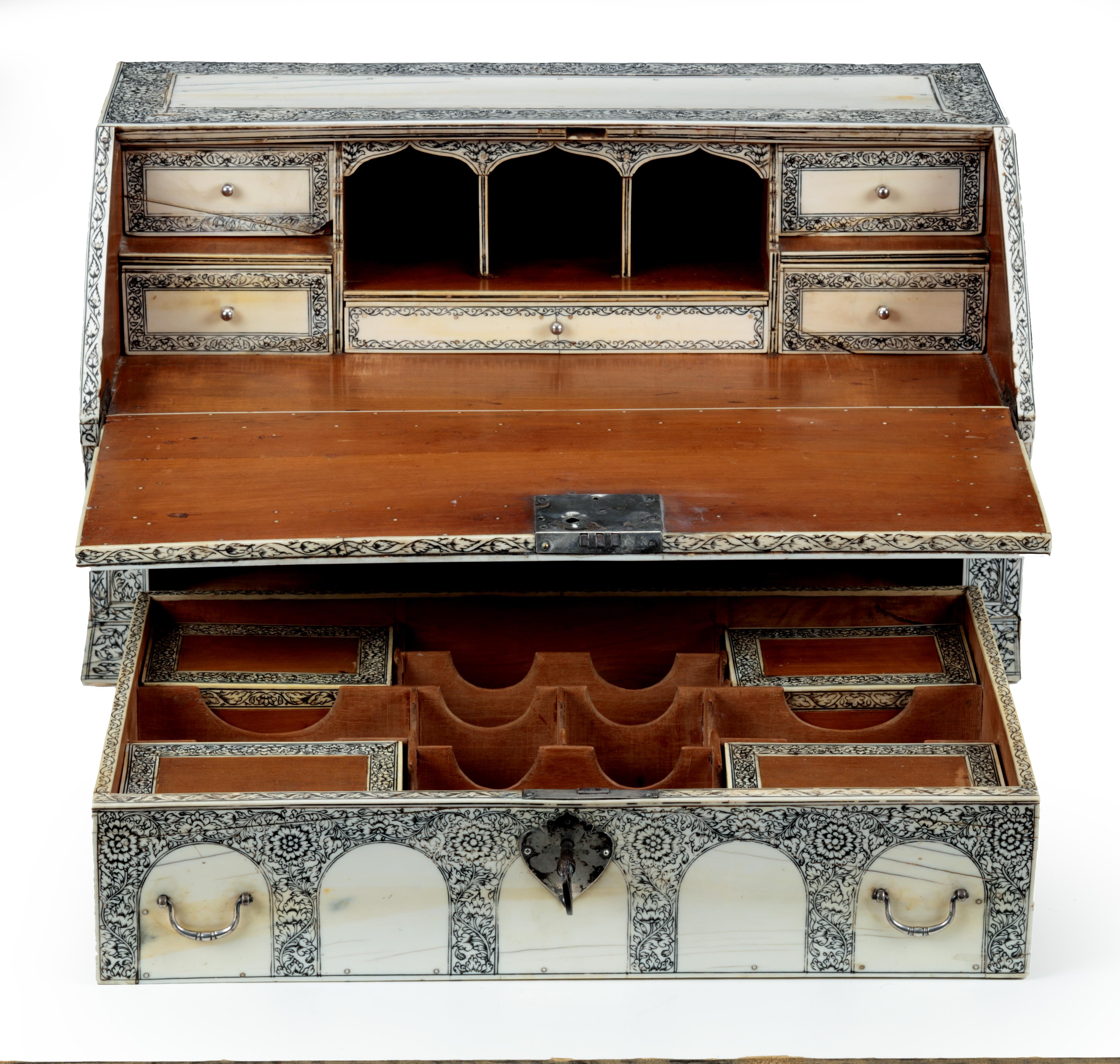 A Vizagapatam pen-engraved veneered sandalwood portable writing desk with silver mounts

India, Coromandel coast, Visakhapatnam, circa 1875

The writing desk with a large drawer under a sloping lid, which opens out into a writing surface,