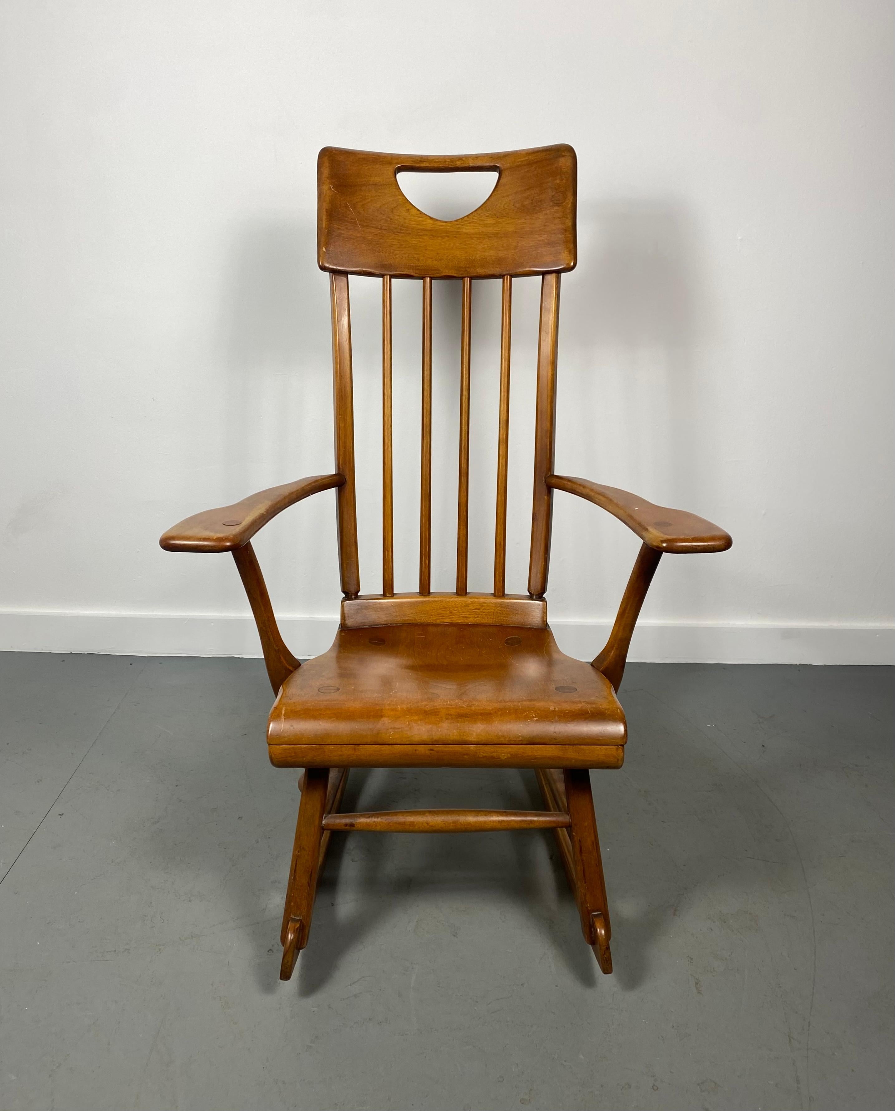 Colonial American style solid maple wood high-back rocking chair designed by Herman de Vries for Sikes Furniture Co. This rocking chair is from the 1930s and is all handmade. Wonderful original condition..patina.. Marked with a labels.. Hand