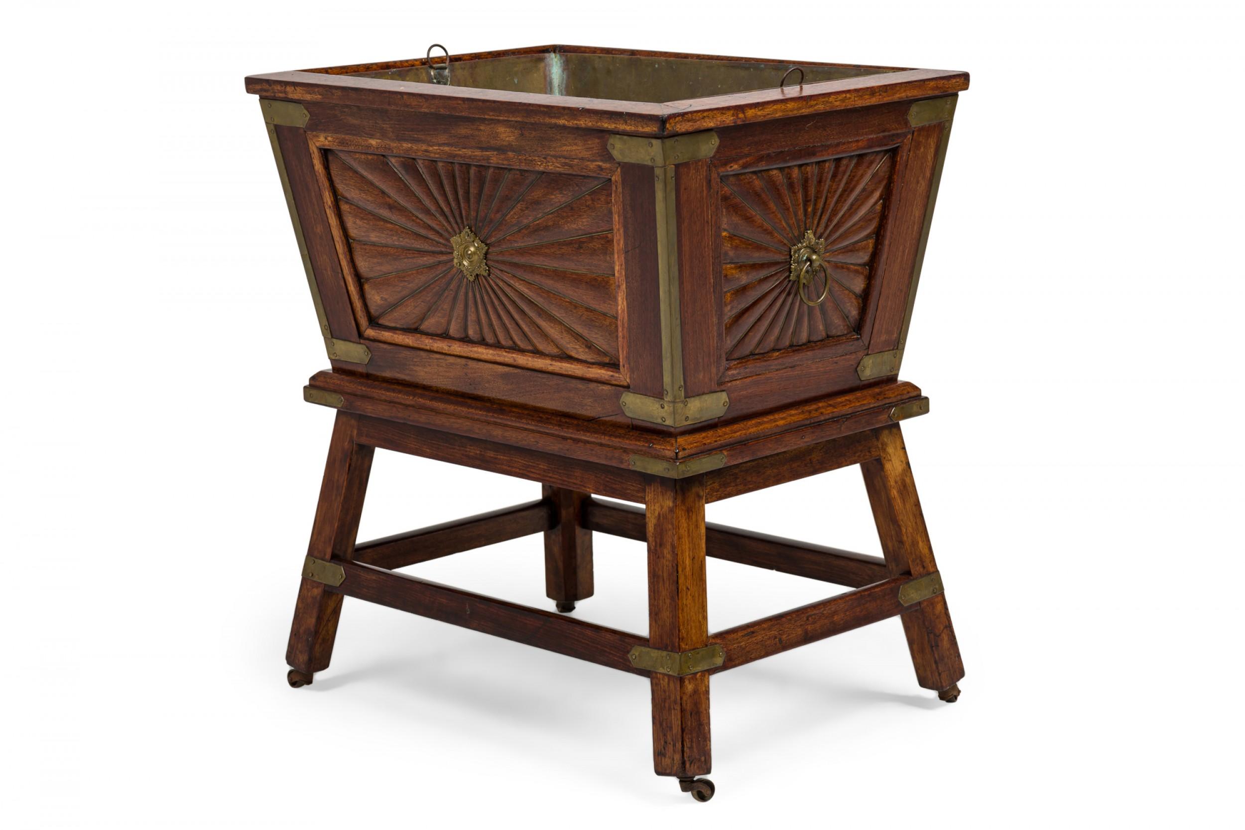Raffreddatore di vino rettangolare affusolato in legno legato all'ottone in stile Coloni Anglo-Indiano Regnecy (XIX secolo), montato su un supporto a 4 gambe con contenitore interno rimovibile in metallo. I lati sono intagliati a mano in riserve a