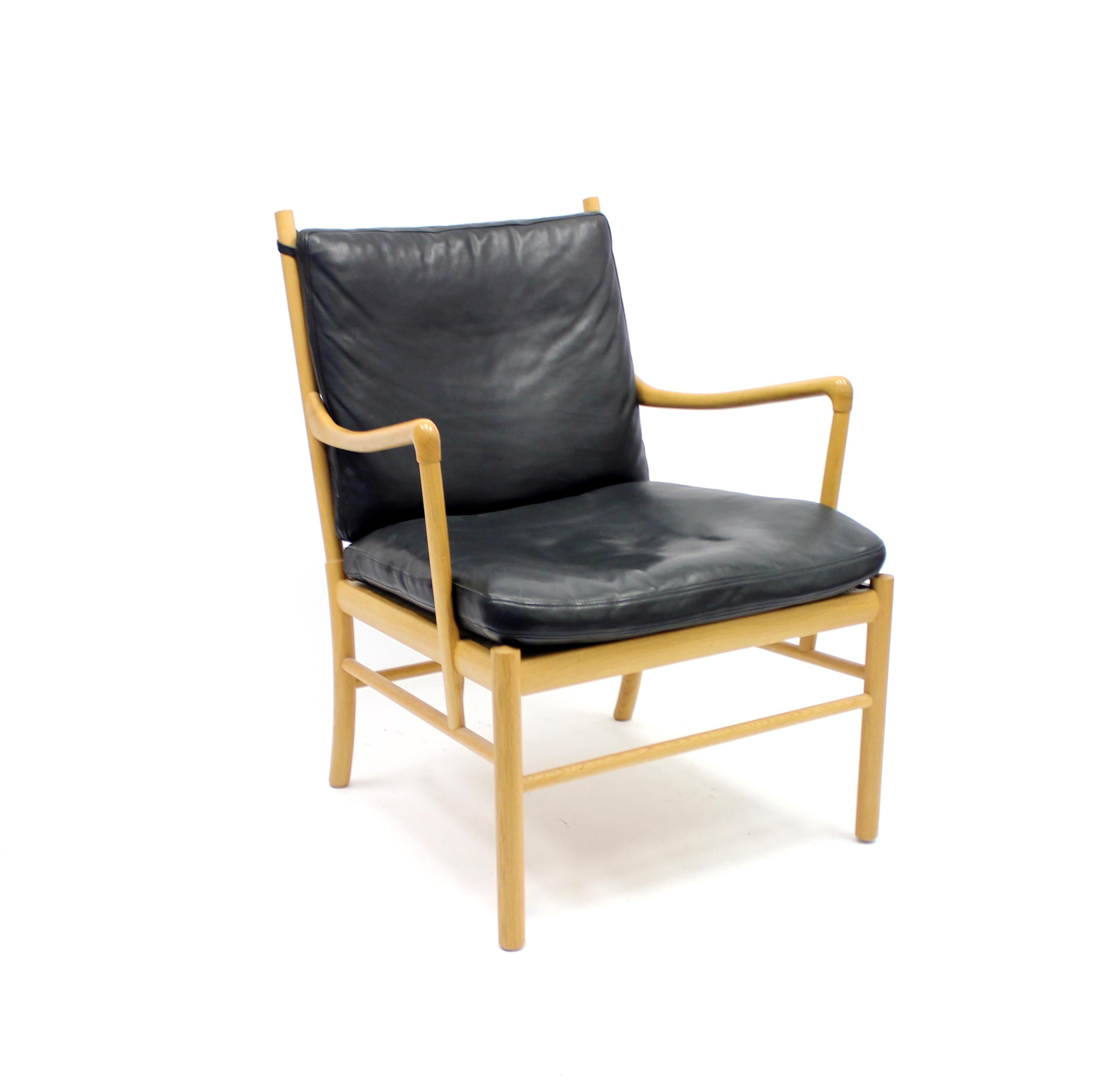 The Colonial chair designed by Ole Wanscher for Carl Hansen & Søn with an oak frame and premium black leather cushions on seat and back. Seat cushion rests on a rattan suspension. This chair was originally designed in 1949 and was from the beginning