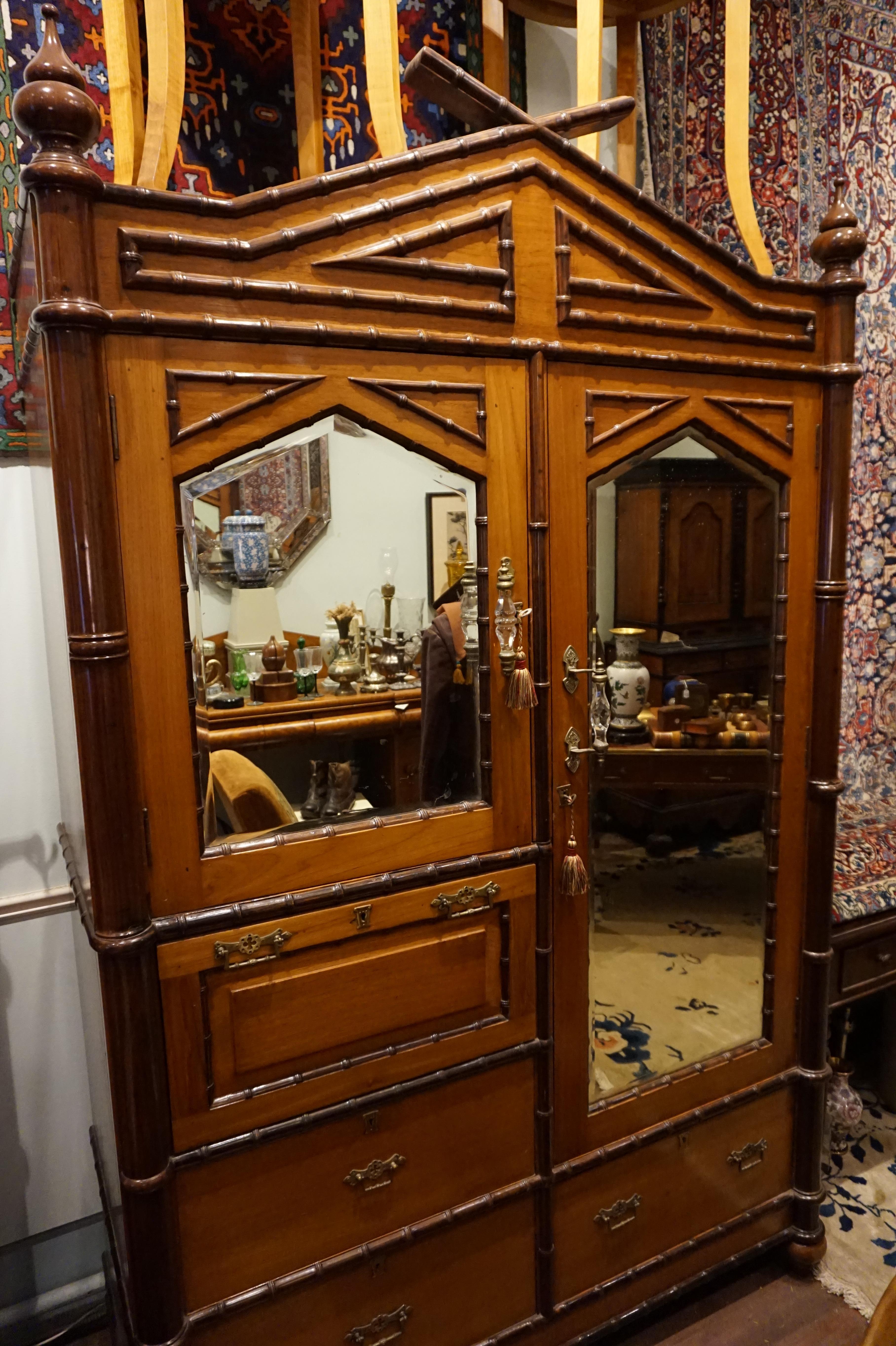 Custom made singular armoire in solid Teak and Rosewood, circa 1880-1890. Attention to detail and old world craftsmanship best describe this piece. Inspired by Orientalist themes this cupboard features a gable moulding, finials, Rosewood wraparound
