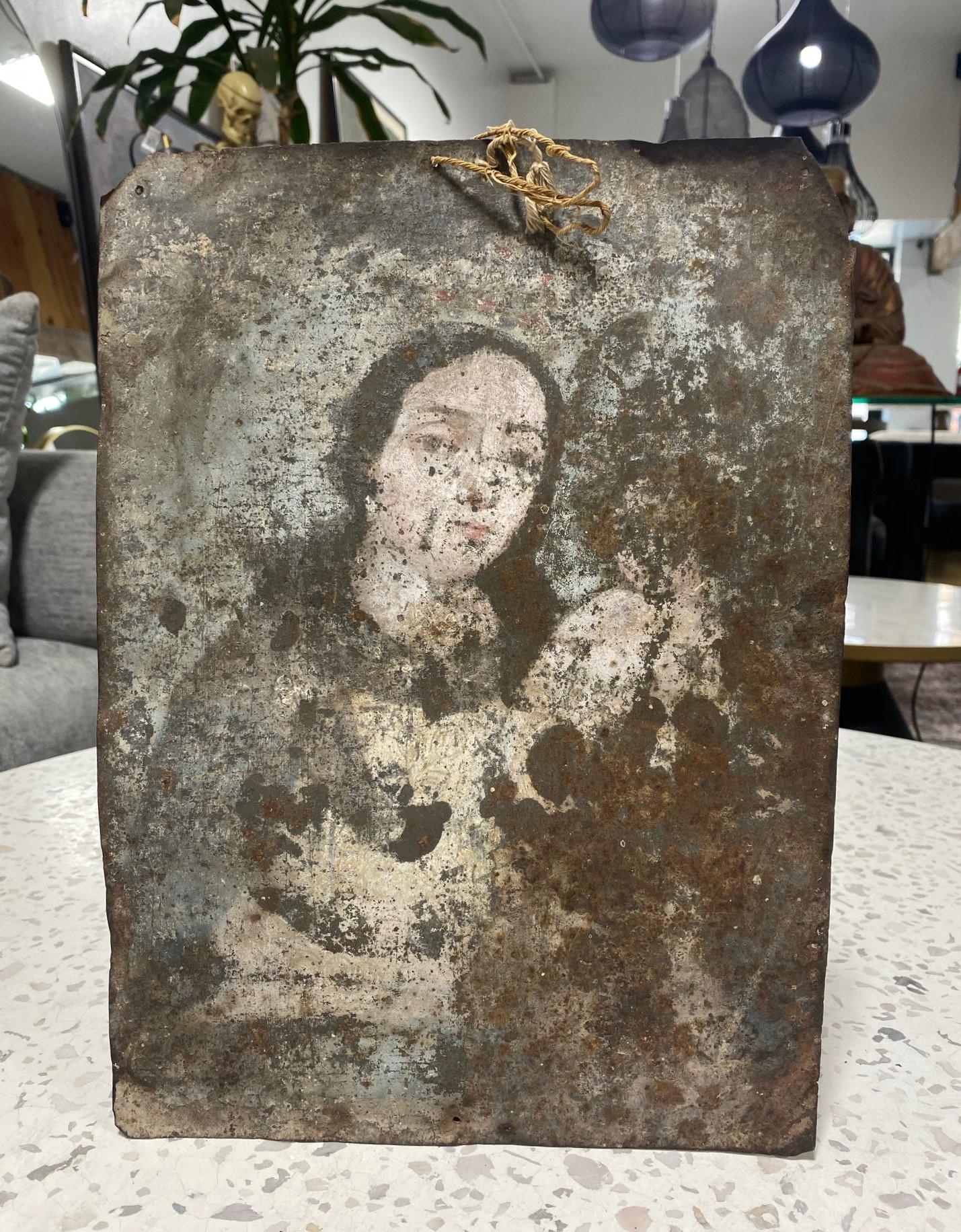 A beautiful 19th-century Spanish Colonial Mexican Folk Art ex-voto retablo lámina painting featuring Mother Mary with the infant Jesus Christ (faded and now almost a ghost-like figure) in her arms.  A beautiful, mesmeric image.  

The work is