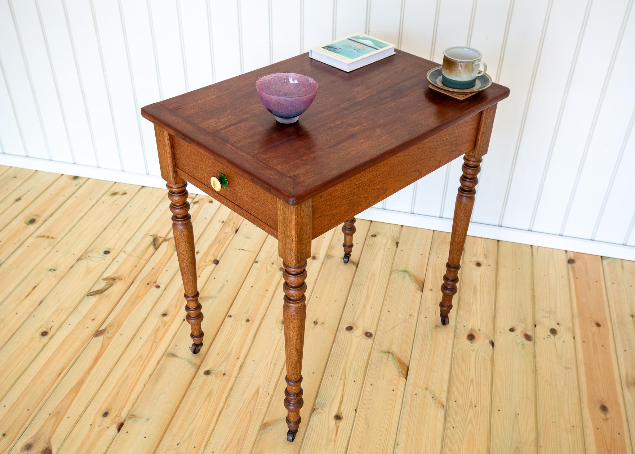 Une très charmante, rare et polyvalente table d'appoint Coloni avec tiroir et roulettes en très bel état d'ancienneté. Probablement fabriquée vers 1900 en Indonésie, cette pièce très attrayante et inhabituelle peut servir de table d'appoint ou de