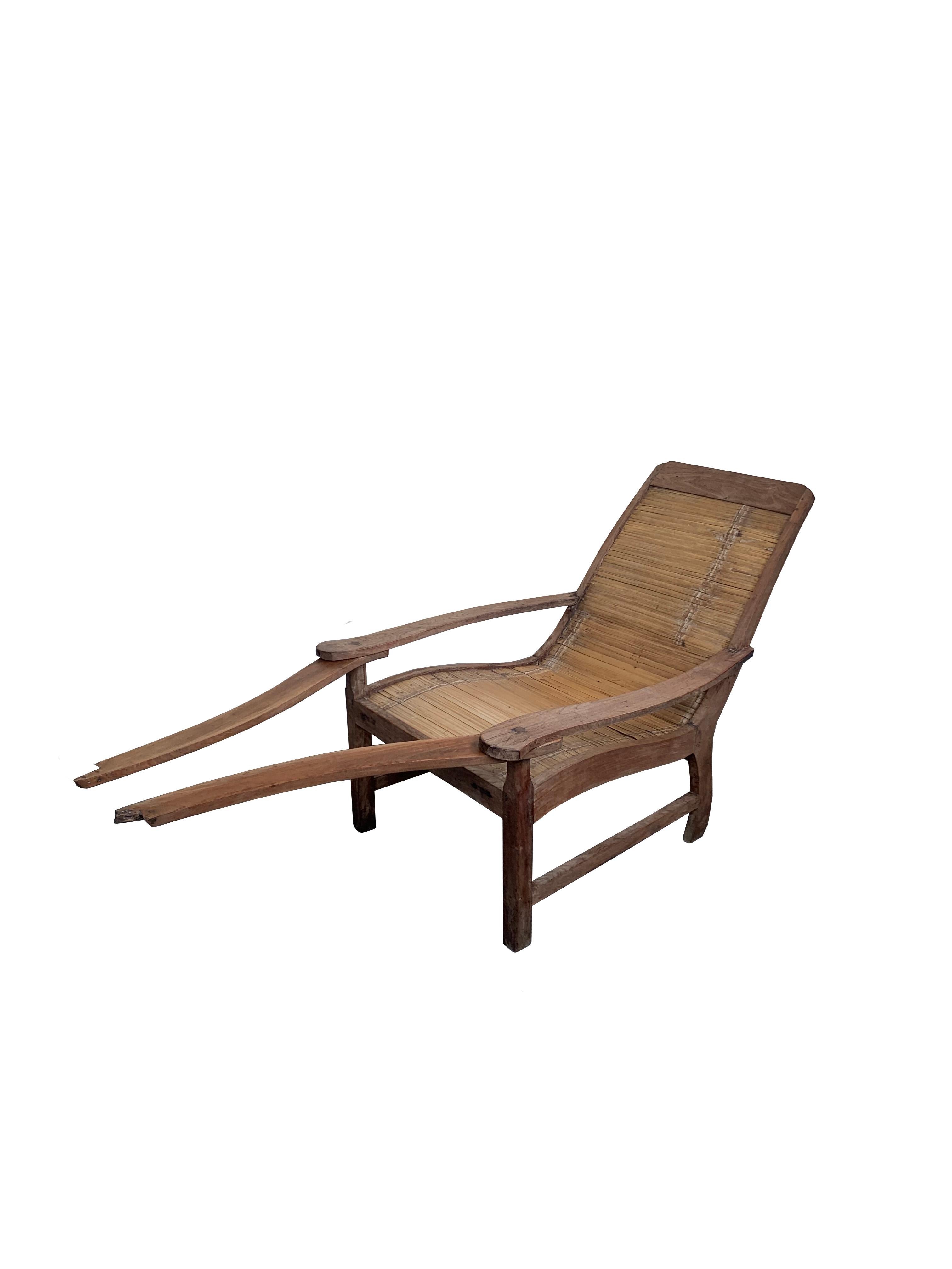 An elegant solid teak wood and bamboo seat plantation chair from the island of Java, Indonesia. This chair features swing-out leg rests that can be kept tucked under the arm rests or fully extended. 

