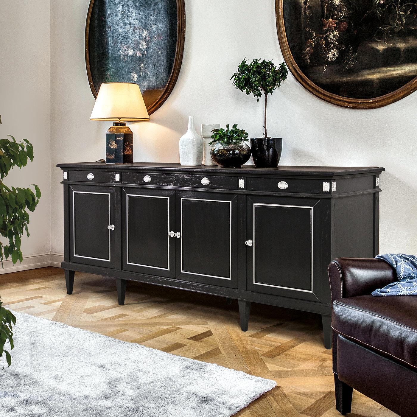 The exotic charm of colonial-style furniture is impeccably exemplified by this exquisite sideboard, its open-pore, oak-veneered MDF structure boasting a glossy black finish that is brightened up by details in antiqued silver leaf accenting the front