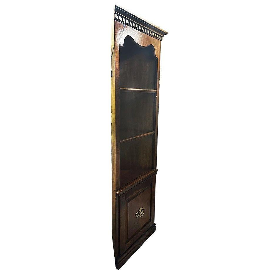 Vetrina angolare in stile Coloni in rovere con intricata lavorazione del legno, ripiani in vetro e luce d'accento incorporata lungo la parte superiore. Il mobile è dotato di 3 ripiani espositivi e di un armadietto a un'anta sotto di esso. Il suo