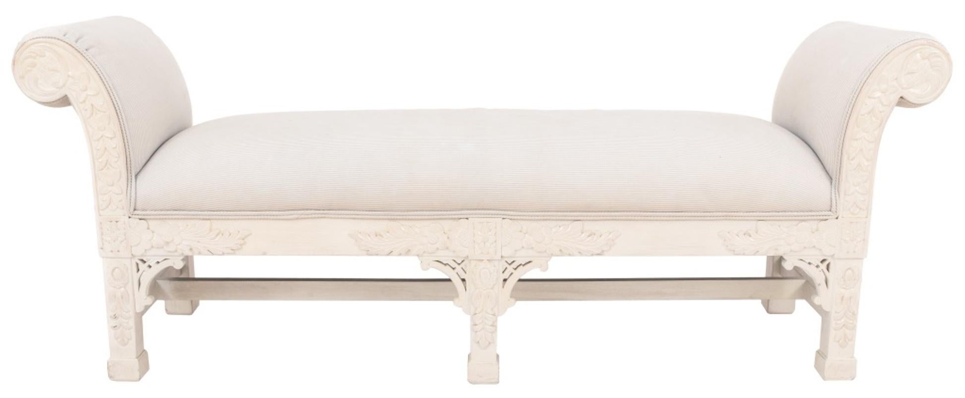 Colonial style white painted carved wood with floral motif upholstered bench, having scrolled armrests. Measures: 24