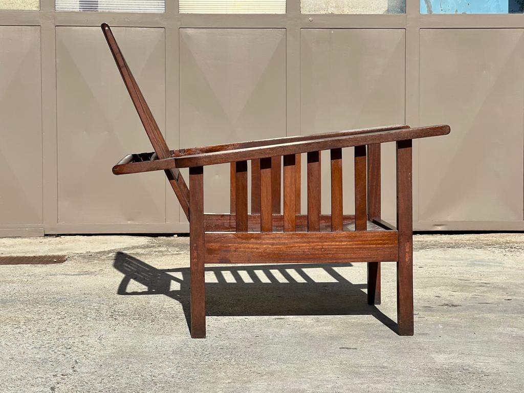 Fauteuil planteur de style colonial 1950. Structure en teck massif, dossier à crémaillère réglable. Bon état