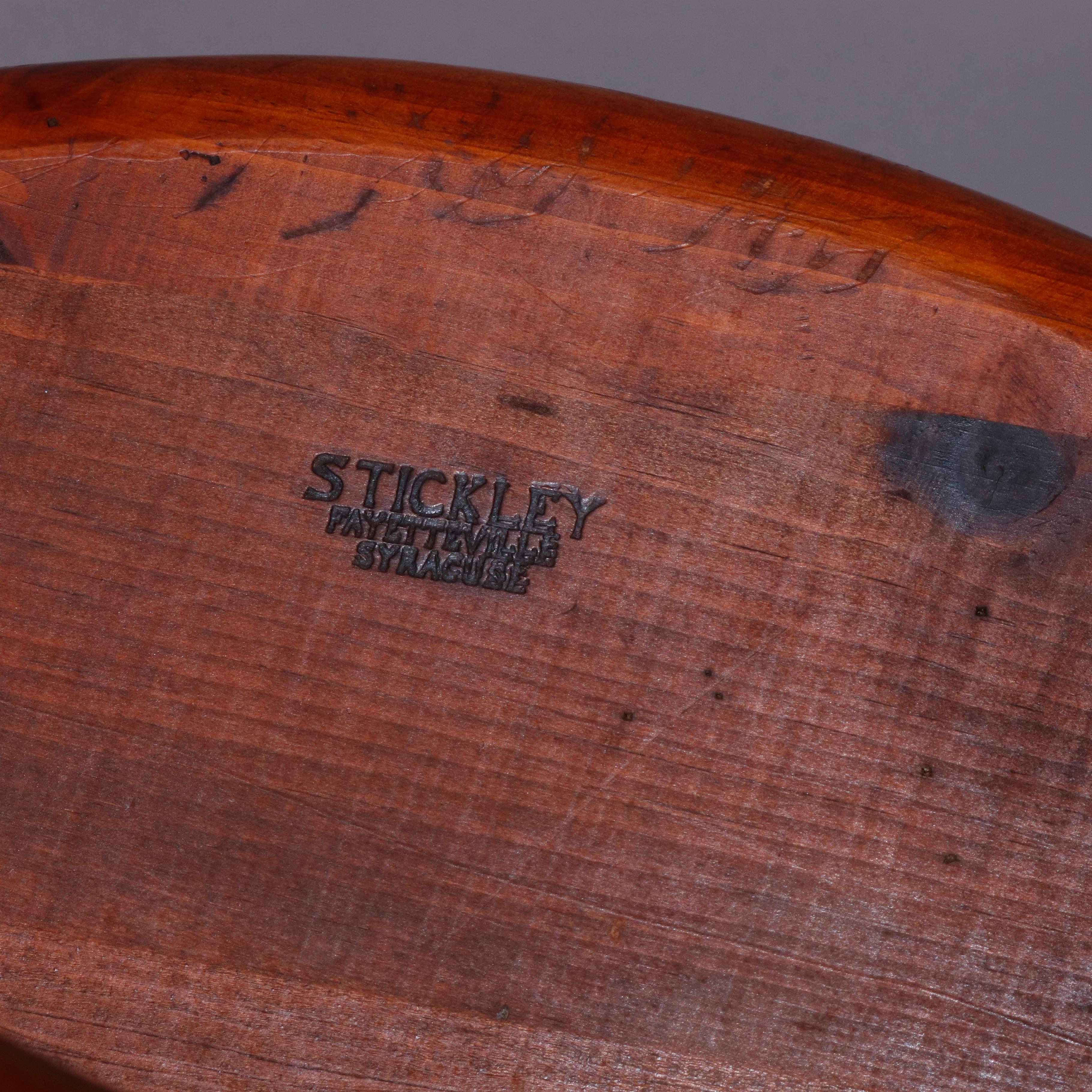 A colonial style Windsor style chair by Stickley features oak pegged construction with fan back and arms having spindles surmounting formed seat and raised on turned legs, Stickley maker brand on seat verso as photographed, 20th century

Measures