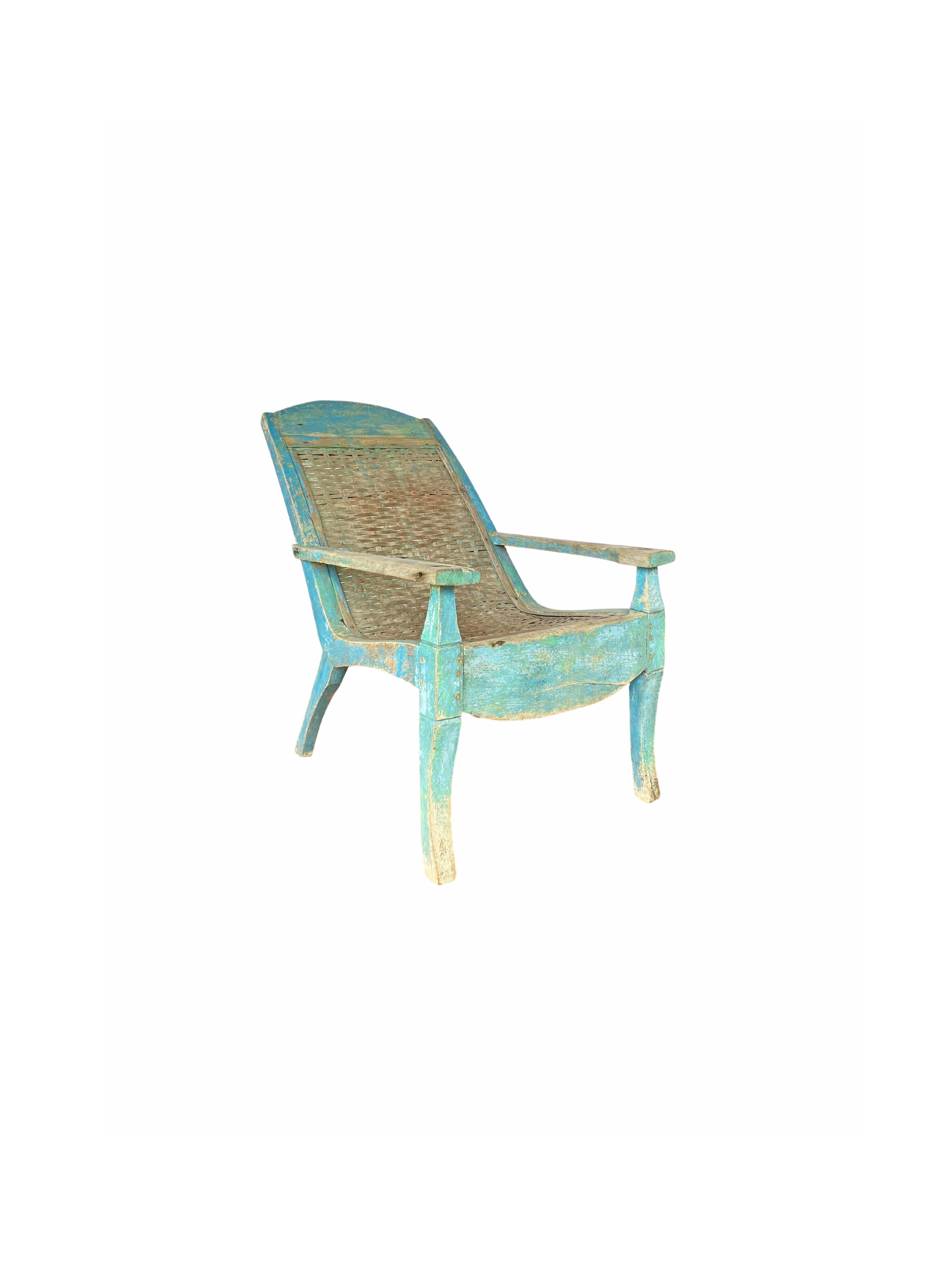 An elegant teak wood and bamboo woven seat plantation chair from the island of Madura, Java, Indonesia. This chair features a wonderful faded blue polychrome and age related patina. A unique and colourful example of Indonesian colonial