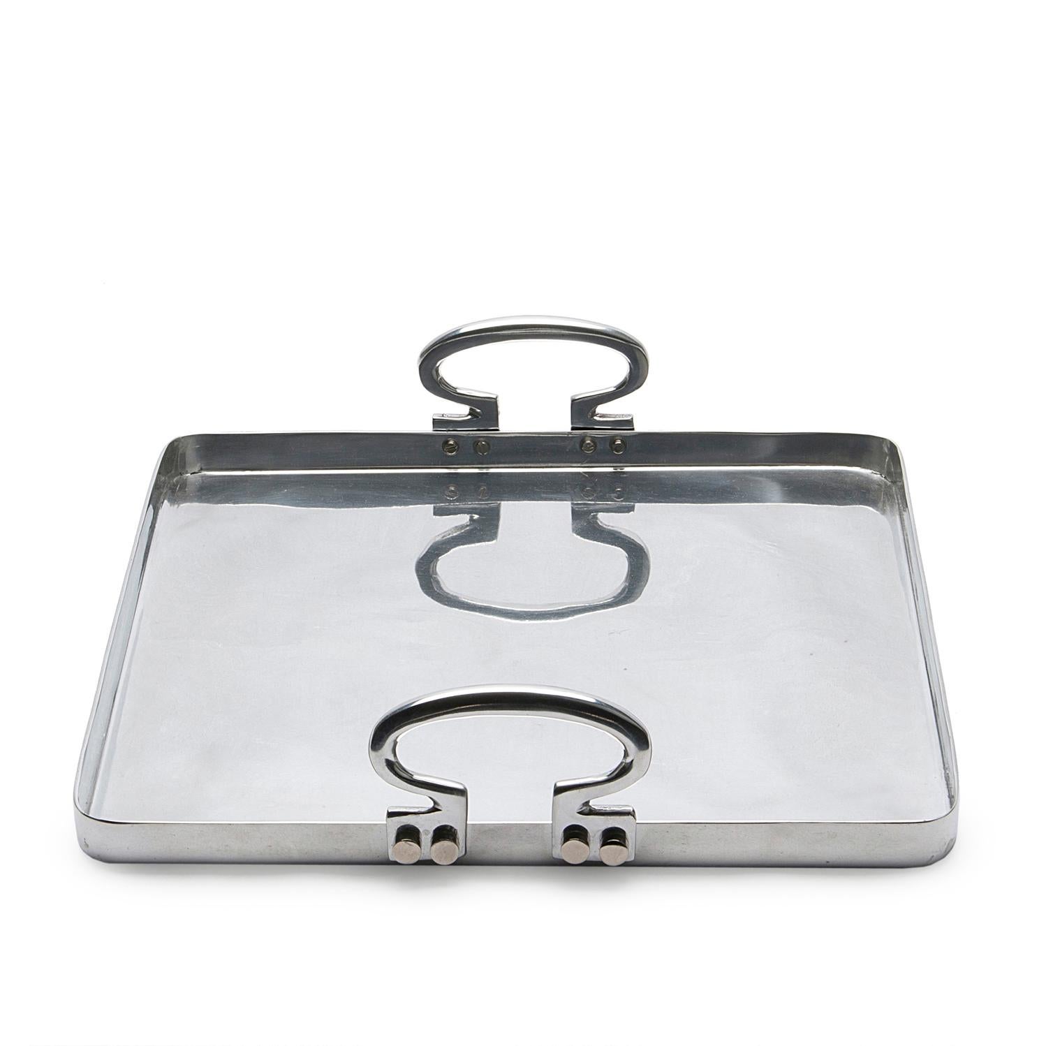 Colony is a polished aluminium tray designed by Aldo Cibic. The square silhouette is minimalist, but the rounded corners and the sinuous handles give to the object a warm and refined look. Colony is perfect on any occasion to serve drinks or food