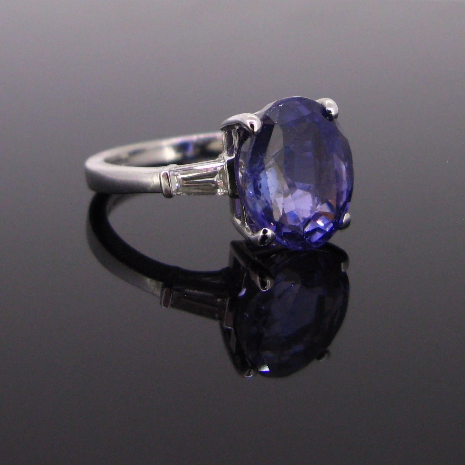 This beautiful band ring is set with a beautiful and a rare Sapphire colour change weighing approximately 7.44ct. It comes with a GCS certificate. The colors tones vary to blue under the daylight to purple in incandescent light. It is shouldered